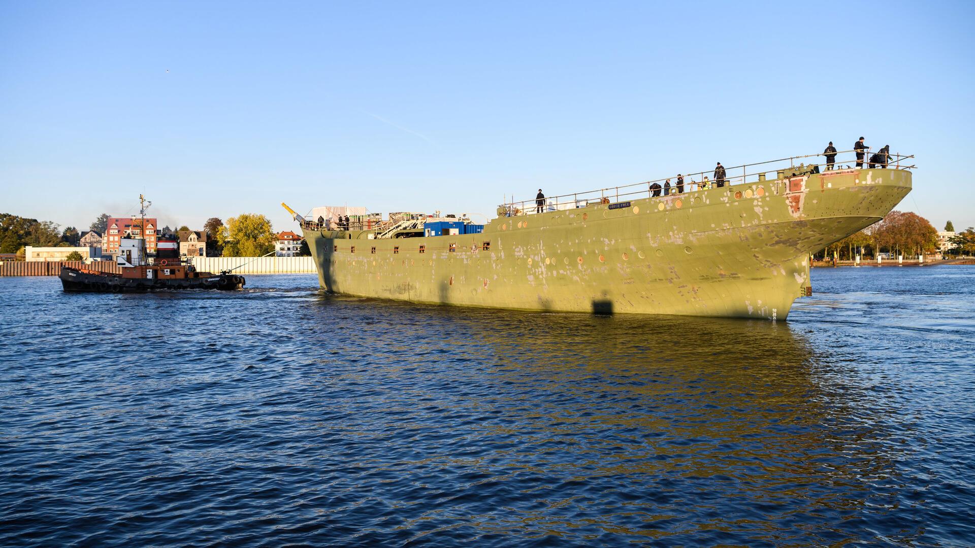 Ein Schlepper zieht ein Schiff über die Weser