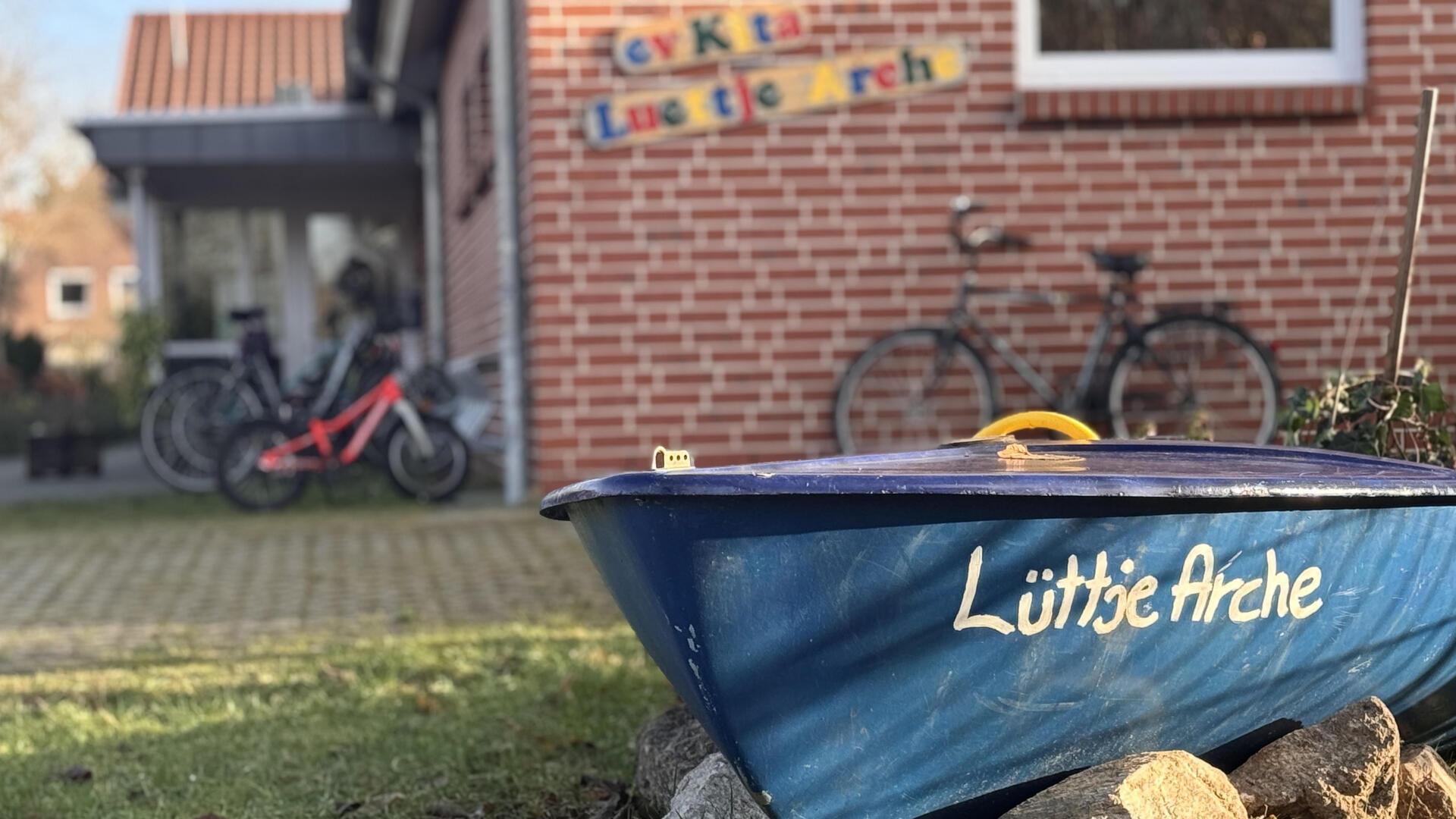 Ein blaues Ruderboot vor einem Haus.