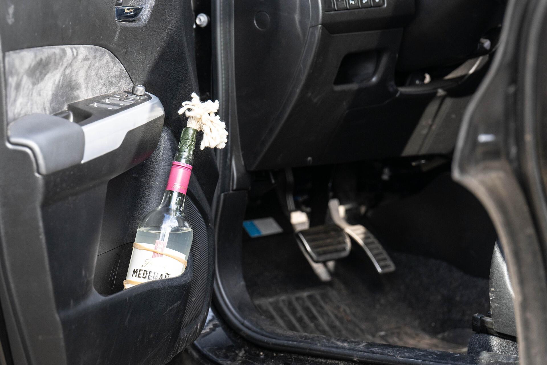 Eine Flasche - möglicherweise ein Molotow-Cocktail - steht in der Tür des Autos ...