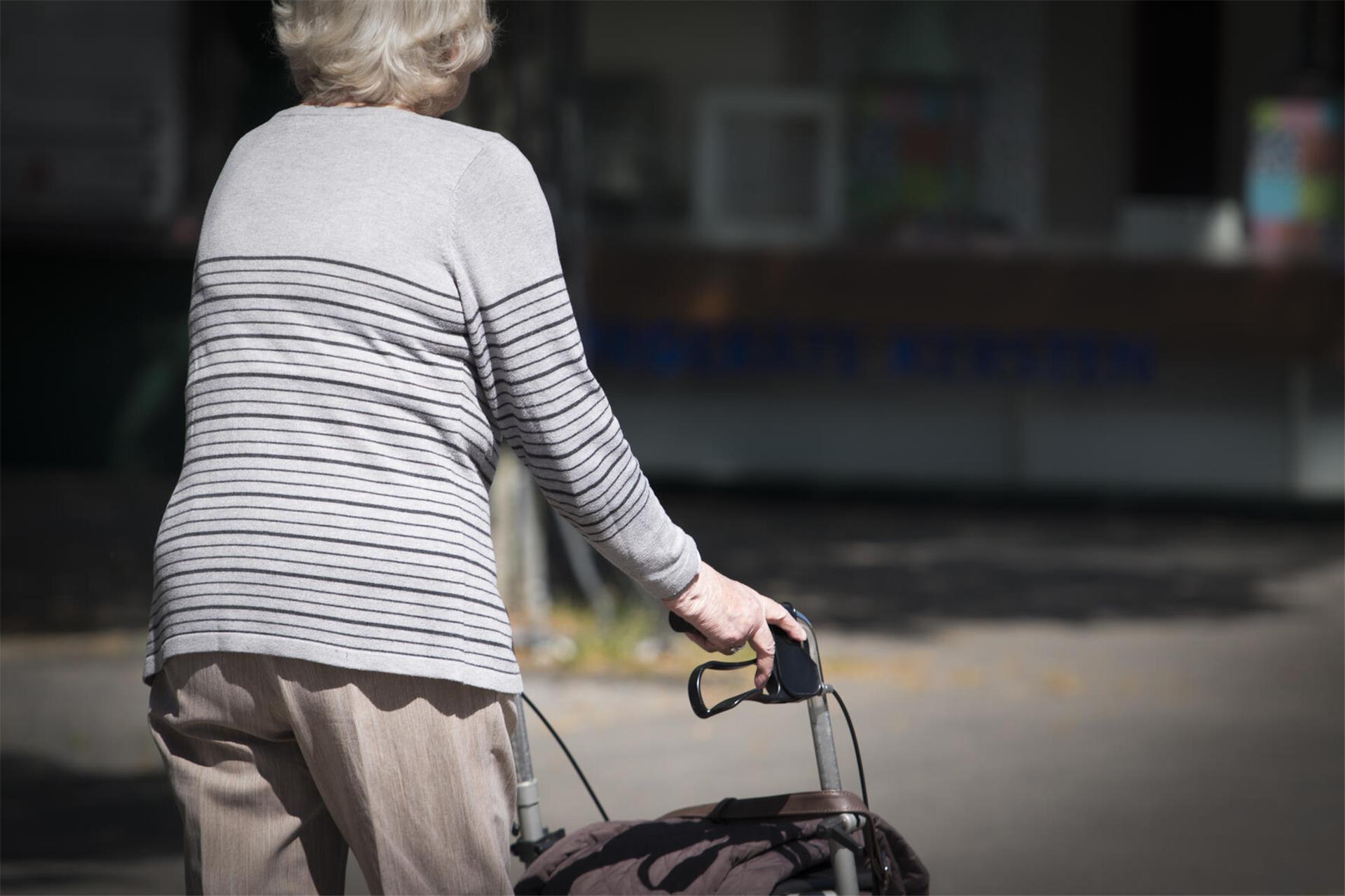 Eine Frau läuft am Rollator.