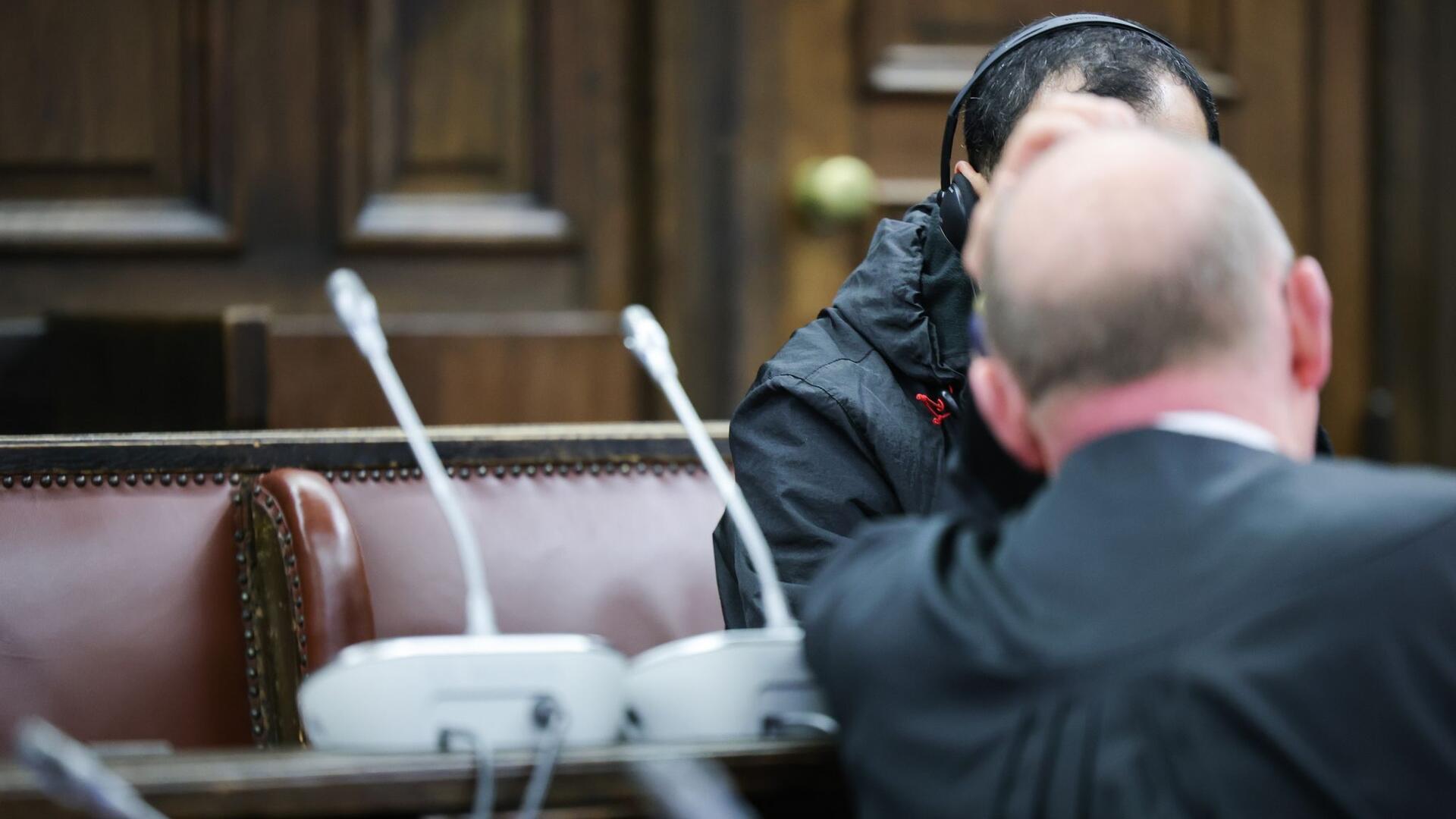 Einer der beiden Angeklagten (verdeckt) spricht mit seinem Anwalt Hannes Linke vor Prozessbeginn im Gerichtssaal des Strafjustizgebäudes.