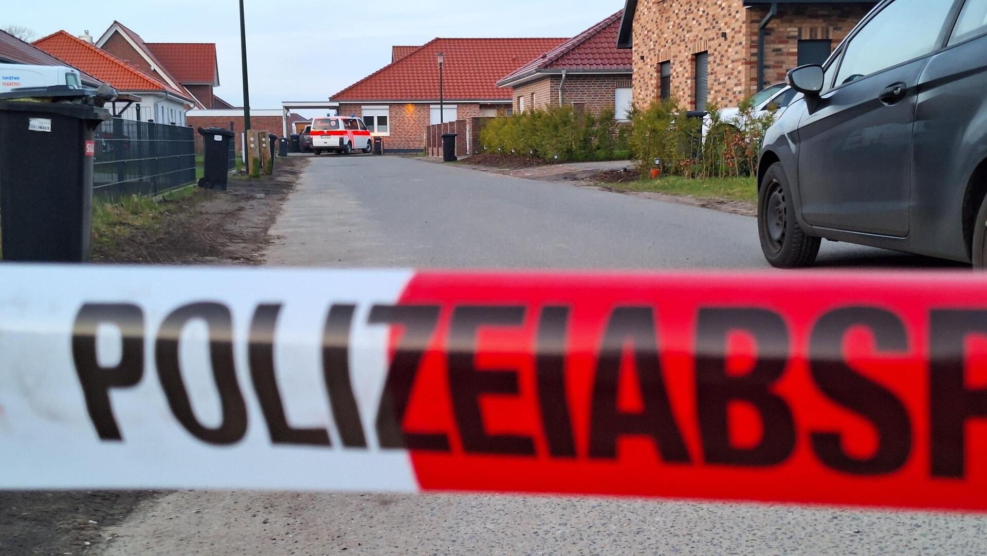 Einsatzkräfte stehen hinter einem Absperrband in Bothel. 