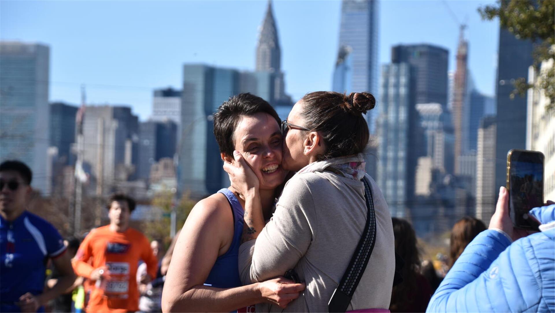 Emotionen pur vor Wolkenkratzer-Kulisse: Claudia Metscher herzt ihre laufende Schwester Stephanie Schriefer mitten in New York bei Kilometer 30.