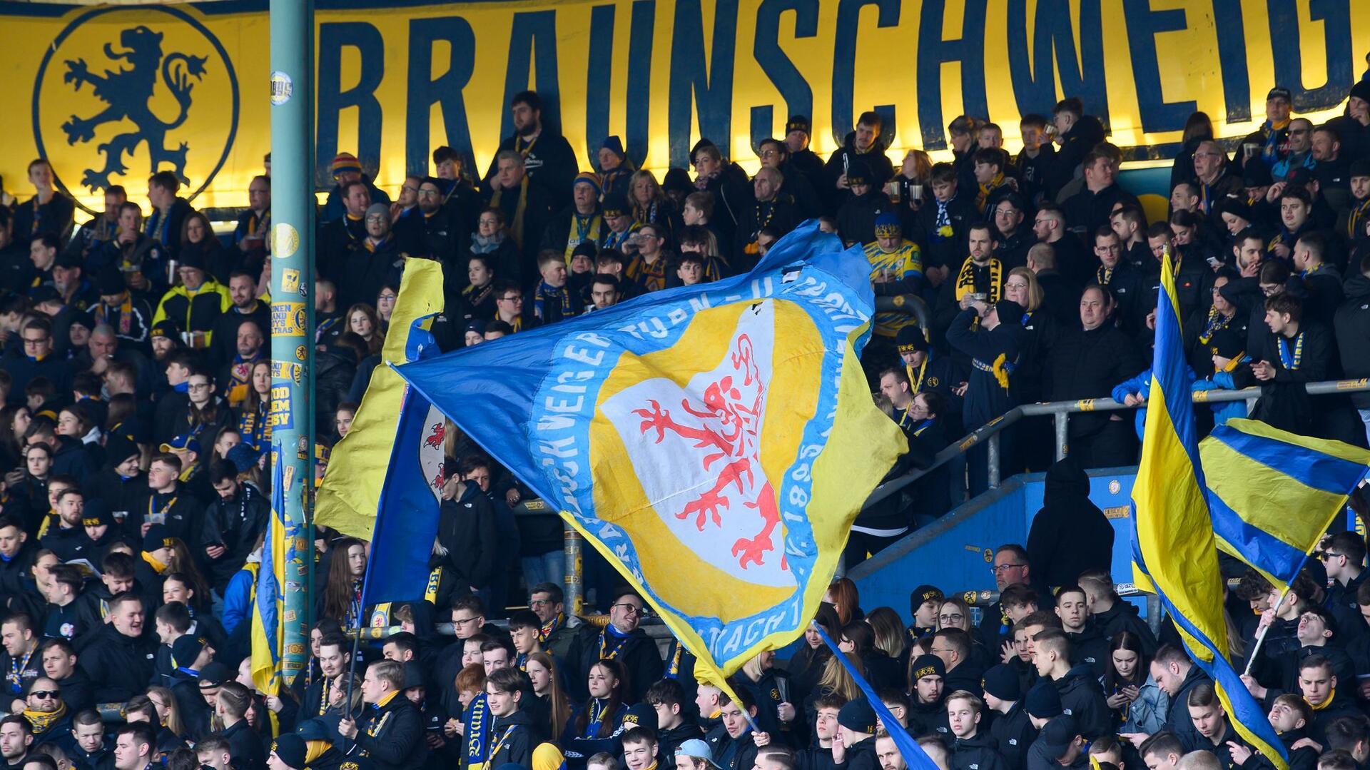 Fans von Eintracht Braunschweig schwenken ihre Flaggen.