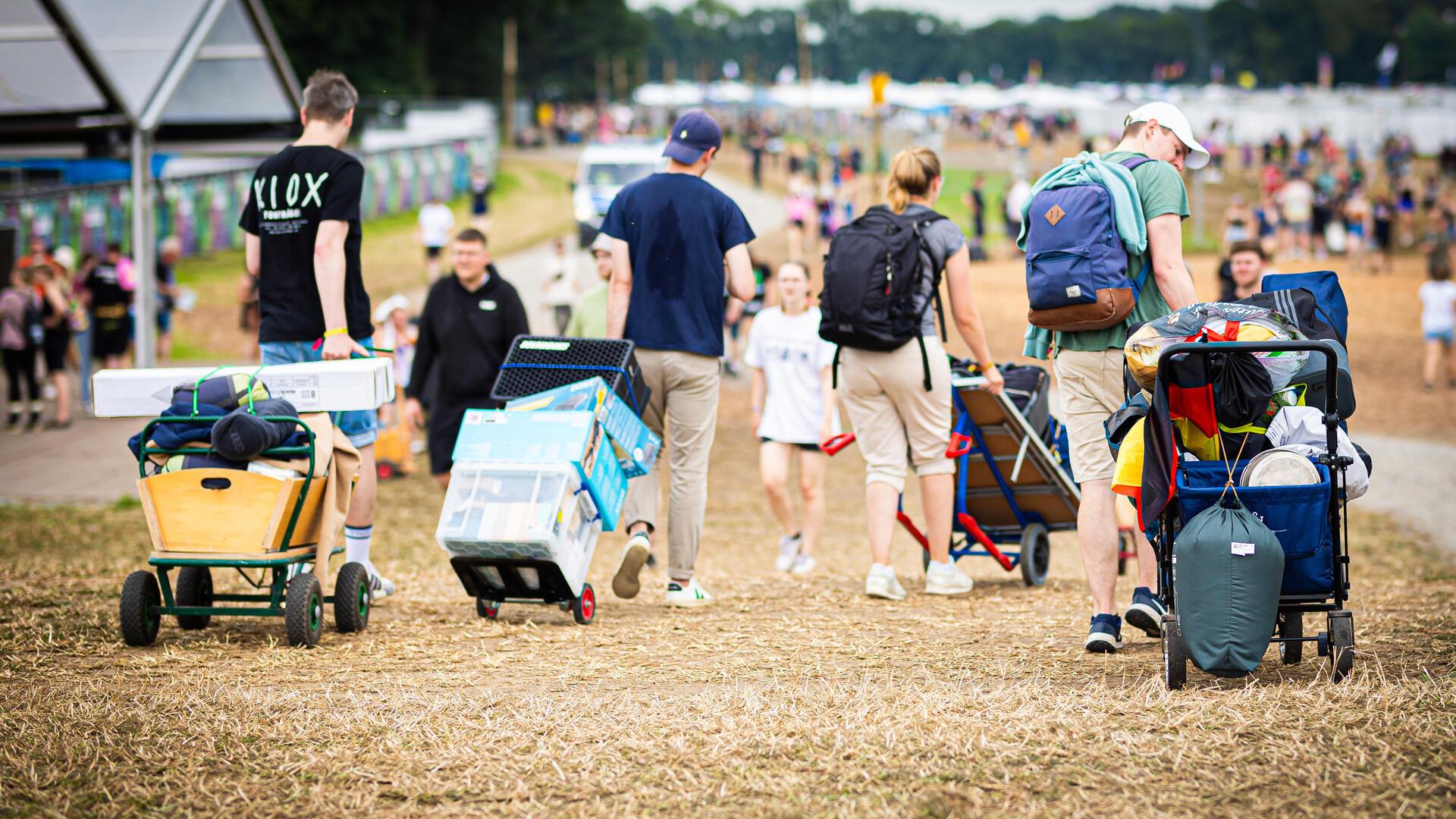 Festivalbesucher kommen mit ihrem Gepäck am Zeltplatz des Hurricane Festivals an.