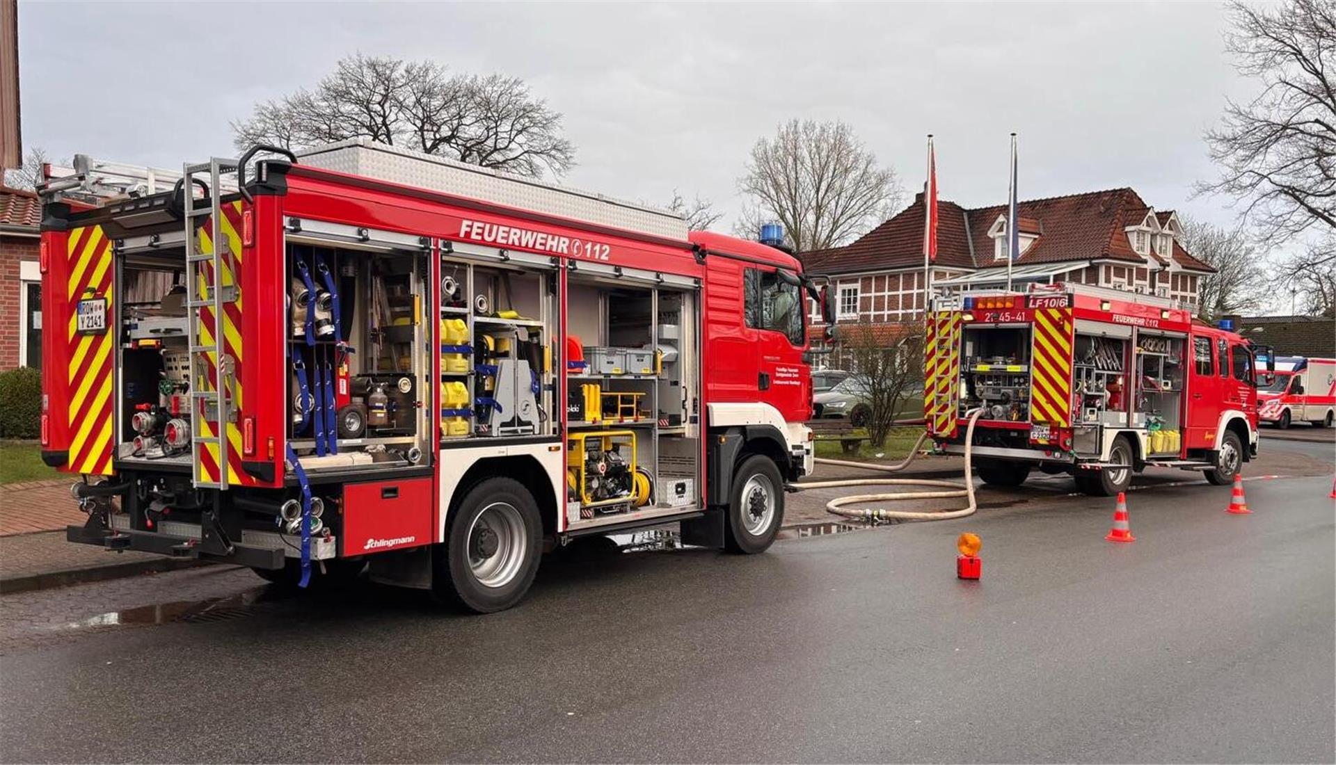 Zwei Feuerwehrfahrzeuge stehen auf einer Straße.