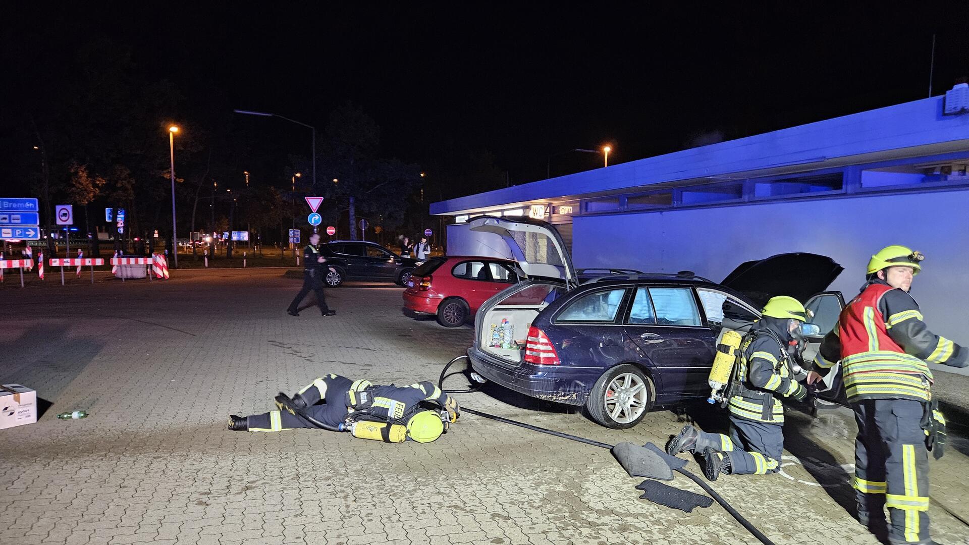 Feuerwehrleute löschen am Freitagabend ein brennendes Auto auf der Rastanlage Grundbergsee Nord.