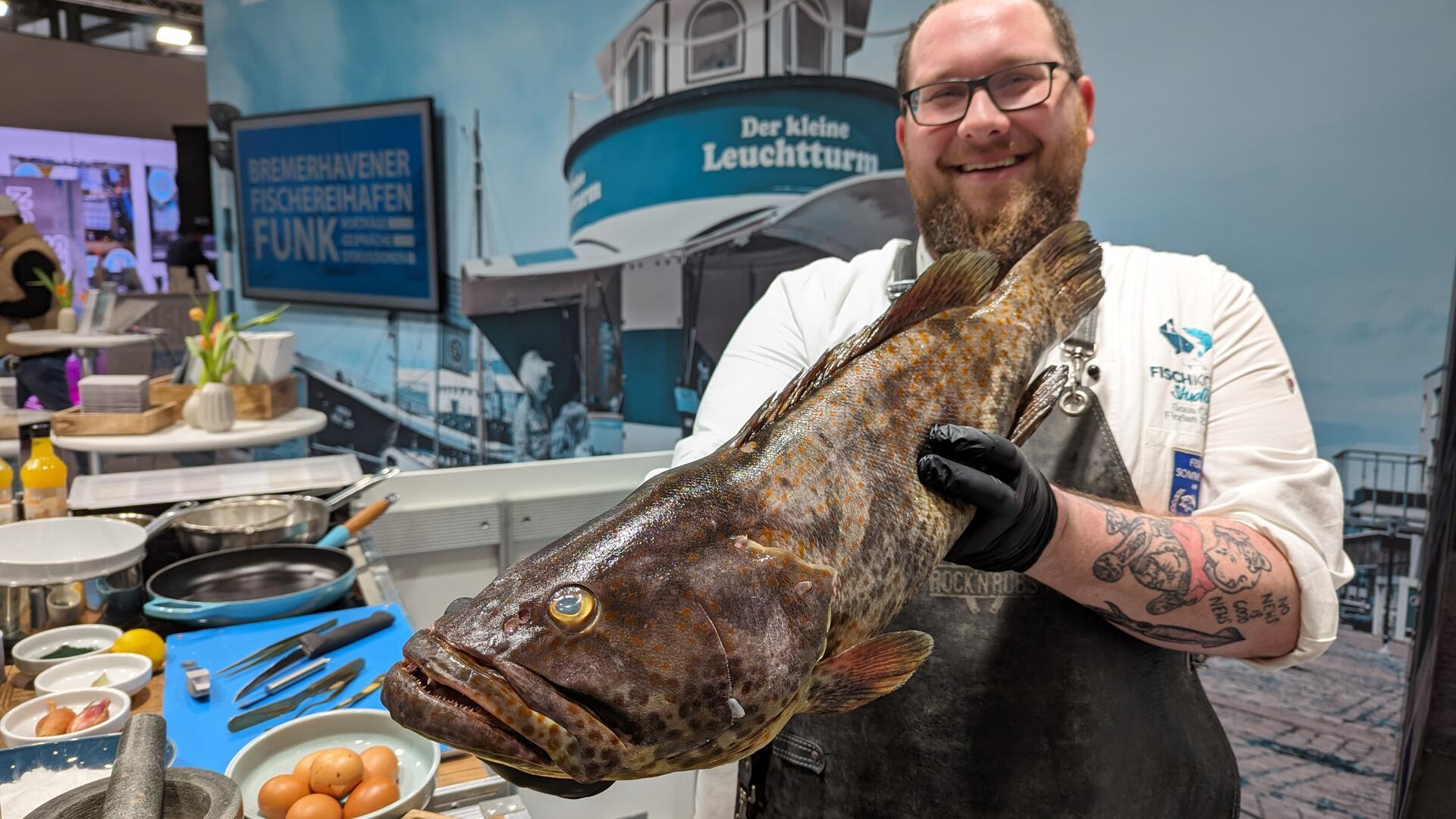 Fischkochstudio-Koch Florian Zerbst präsentiert auf der Fischmesse einen Zackenbarsch – passend zum Thema „Bremerhavener auf Zack(enbarsch).