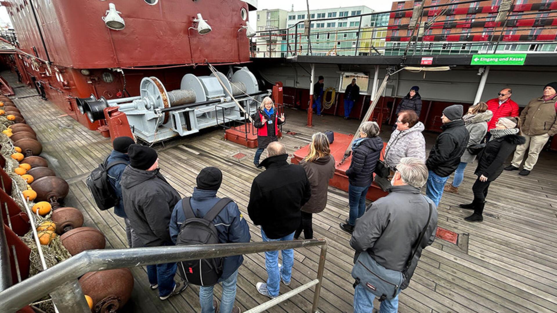 Menschen stehen auf einem Fischtrawler.