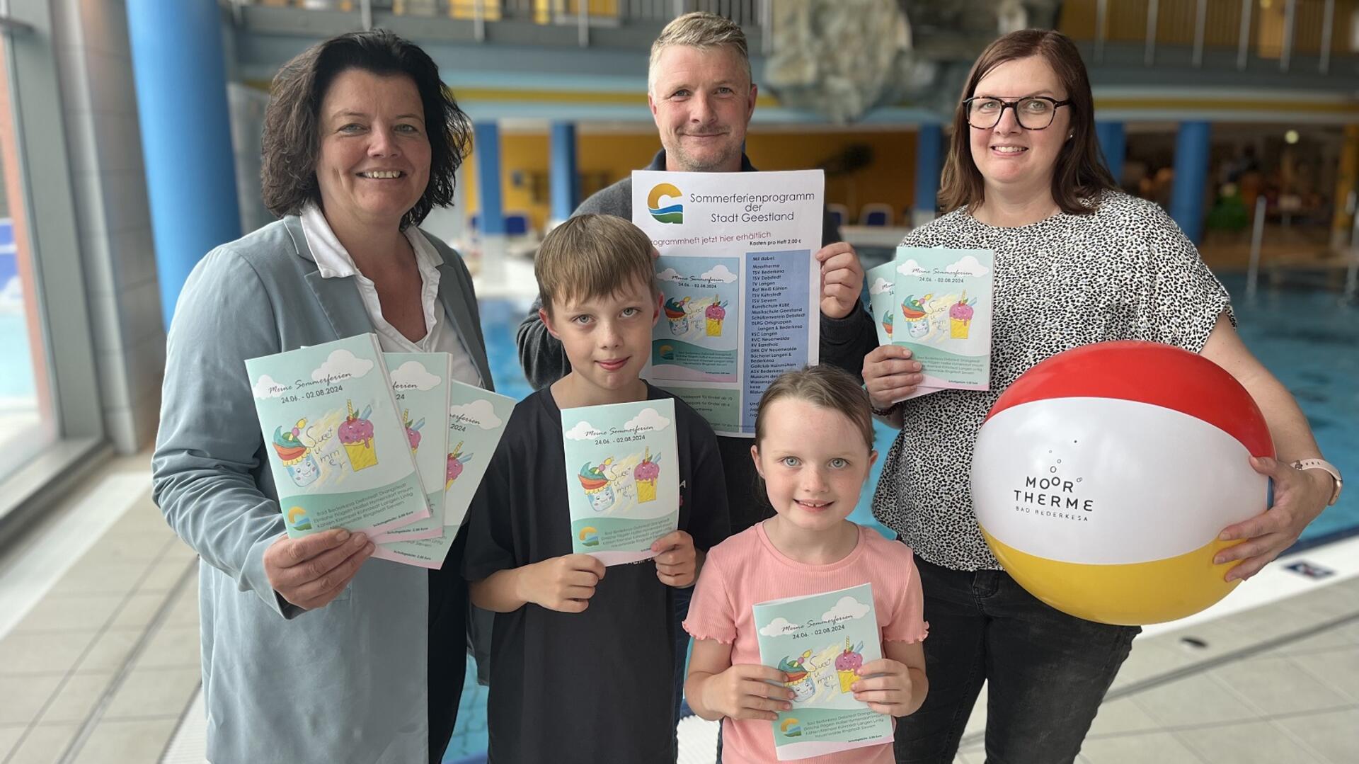 Zwei Frauen, ein Mann und zwei Kinder stehen in einem Schwimmbad.