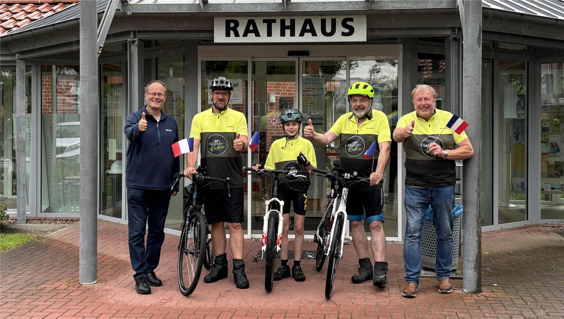 Freitag früh starteten sie in Loxstedt: Jochen Luitjens (von links mit gelben Trikots), Timon und Jörg Fierlings sowie Eymer Köhnken. Der stellvertretende Verwaltungschef Holger Rasch (ganz links) verabschiedete sie.