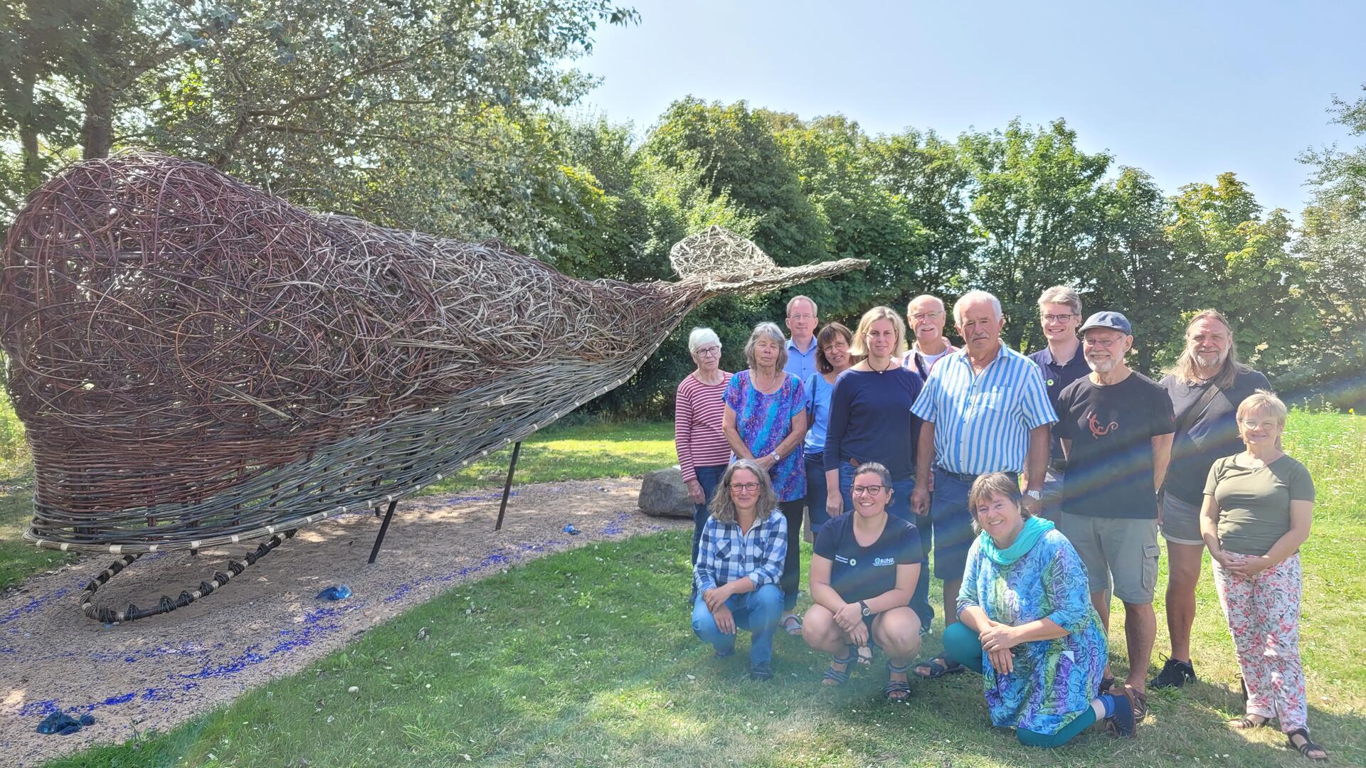 Freuen sich über Wremens Weidenwal: Claudia Reuter (hockend, 3. v.l.) mit Weidenflechtern, Damaris Margaritis und Dr. Matthias Mertzen vom Nationalparkhaus sowie Kurdirektorin Sandra Langheim, Ortsbürgermeister Hanke Pakusch und Jan-Hinrik Dircksen vom Wremer Verkehrsverein.