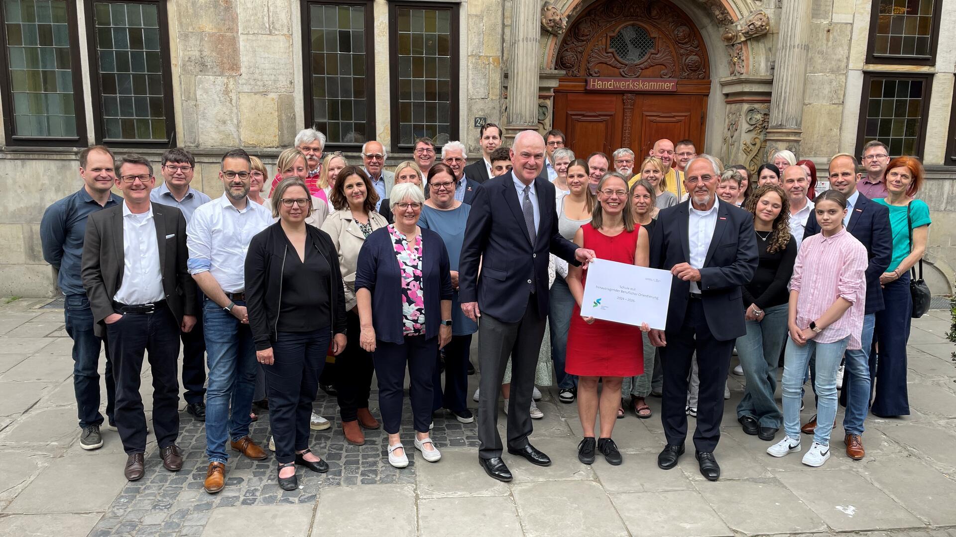 Eine Gruppe Menschen steht vor dem Eingang des Gewerbehauses der Handwerkskammer Bremen