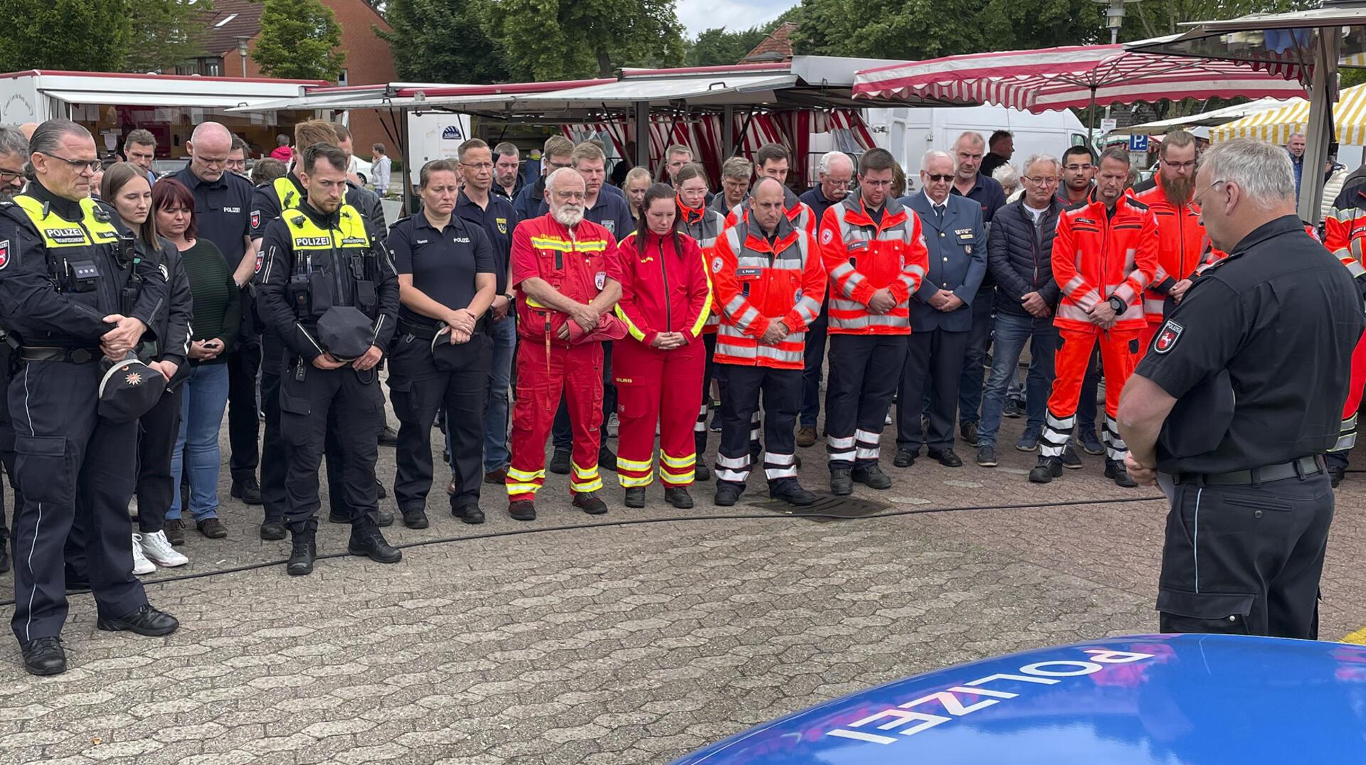 Gedenkminute am Rande des Bremervörder Wochenmarktes: Rund 60 Vertreter von Polizei, Feuerwehr, DRK-Rettungsdienst und DLRG gedachten am Freitag um 11.34 Uhr des eine Woche zuvor in Mannheim ermordeten Polizisten Rouven L.