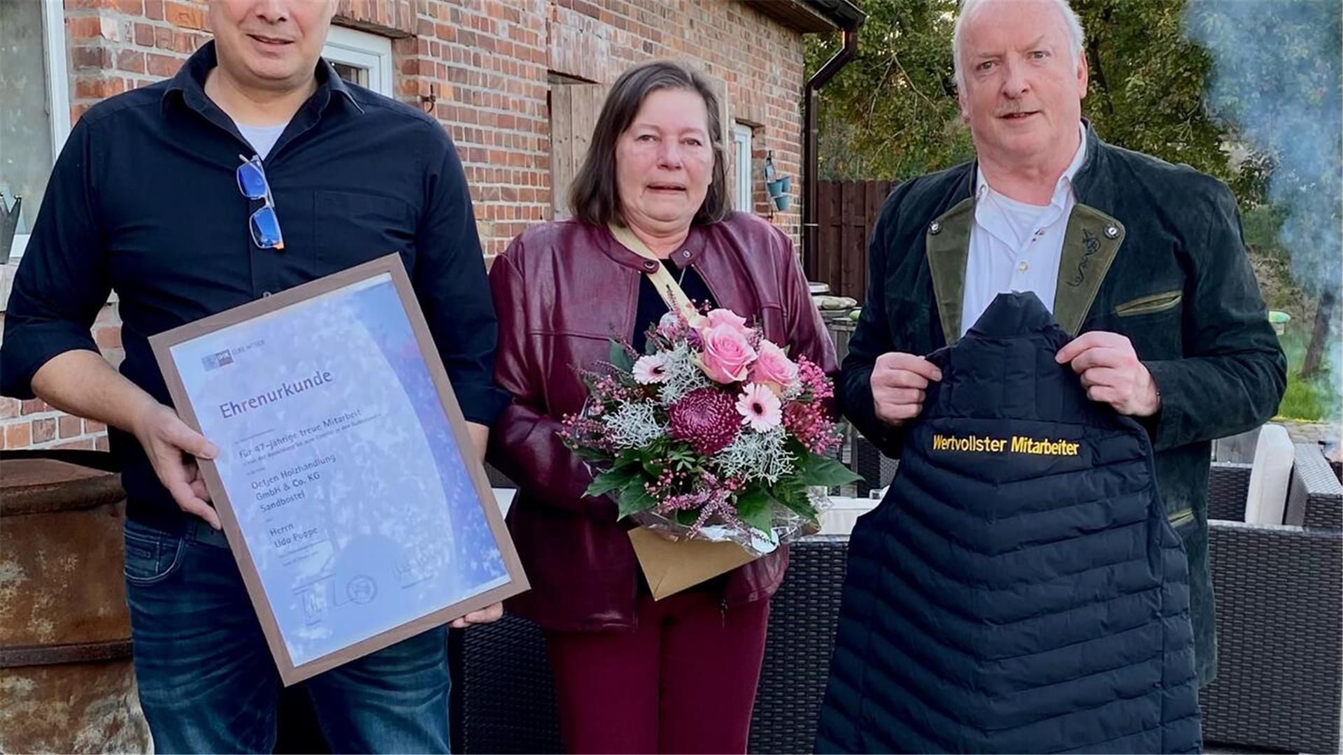 Geschäftsführer Jens Oetjen (links) bedankte sich mit vielen Geschenken bei Udo Poppe (mit Ehefrau ) für dessen 47-jährige Treue zum Unternehmen. Foto: Oetjen