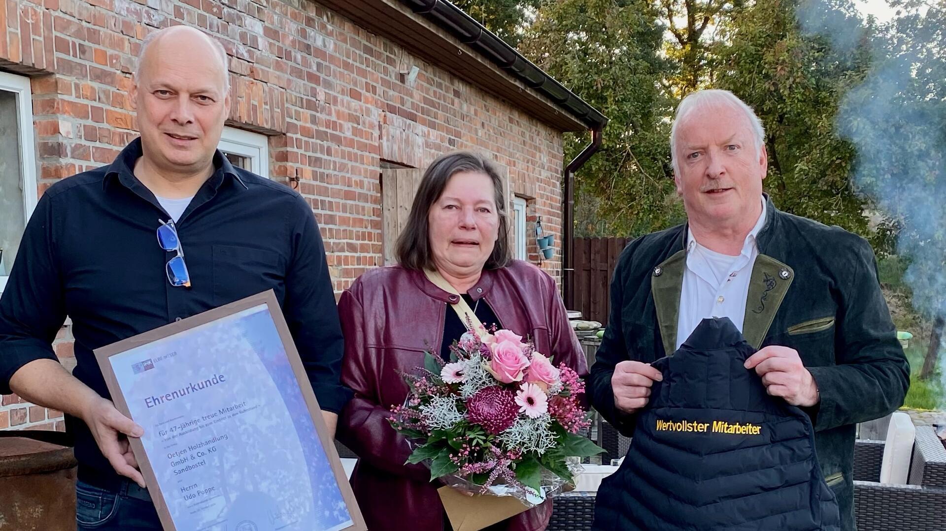 Geschäftsführer Jens Oetjen (links) bedankte sich mit vielen Geschenken bei Udo Poppe (mit Ehefrau ) für dessen 47-jährige Treue zum Unternehmen. Foto: Oetjen