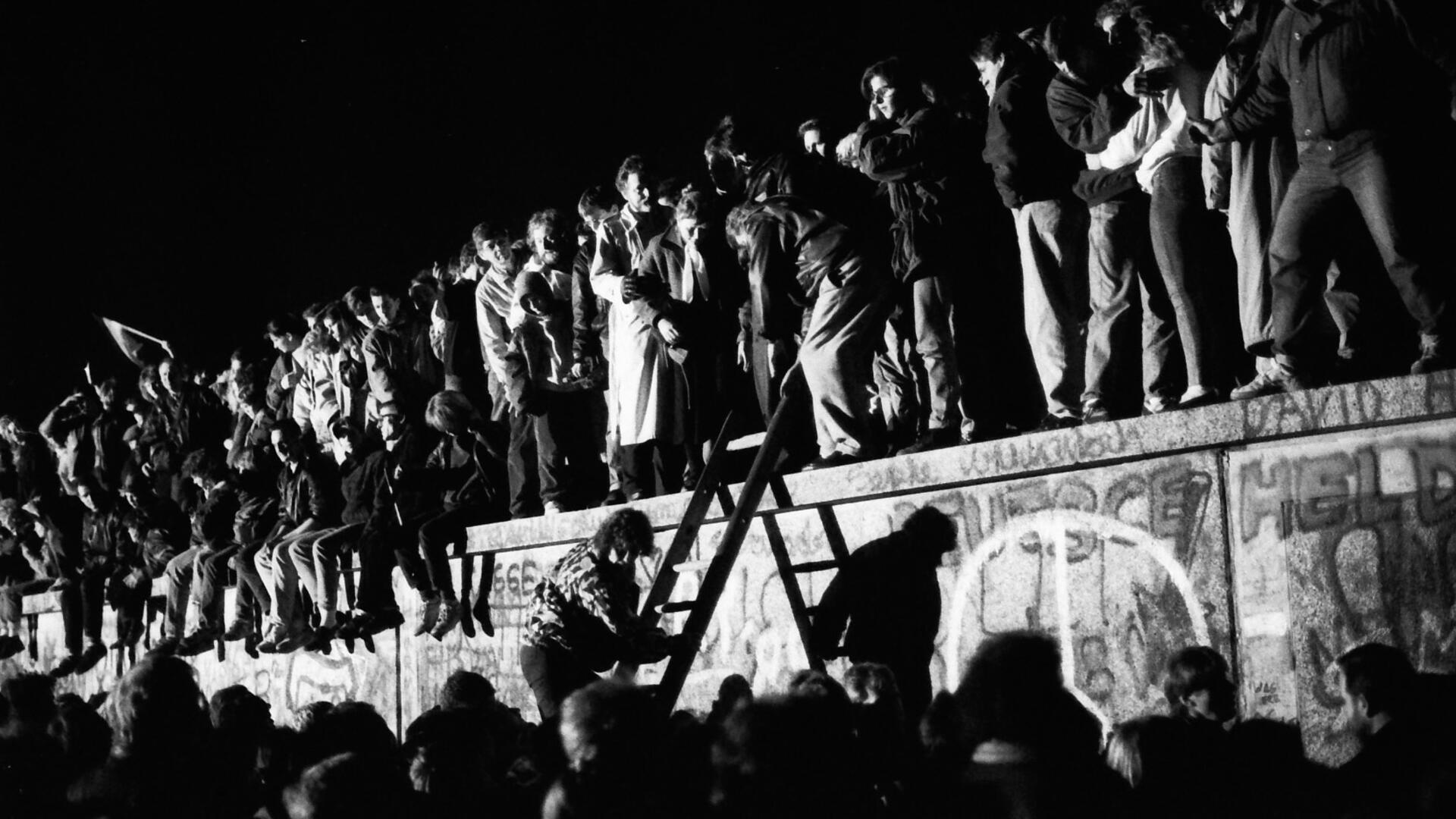 Gespenstisch: Die Mauer vor dem Brandenburger Tor wird von Hunderten erobert. Die Angst vor dem „antifaschistischem Schutzwall“ weicht der Freude über die Grenzöffnung.