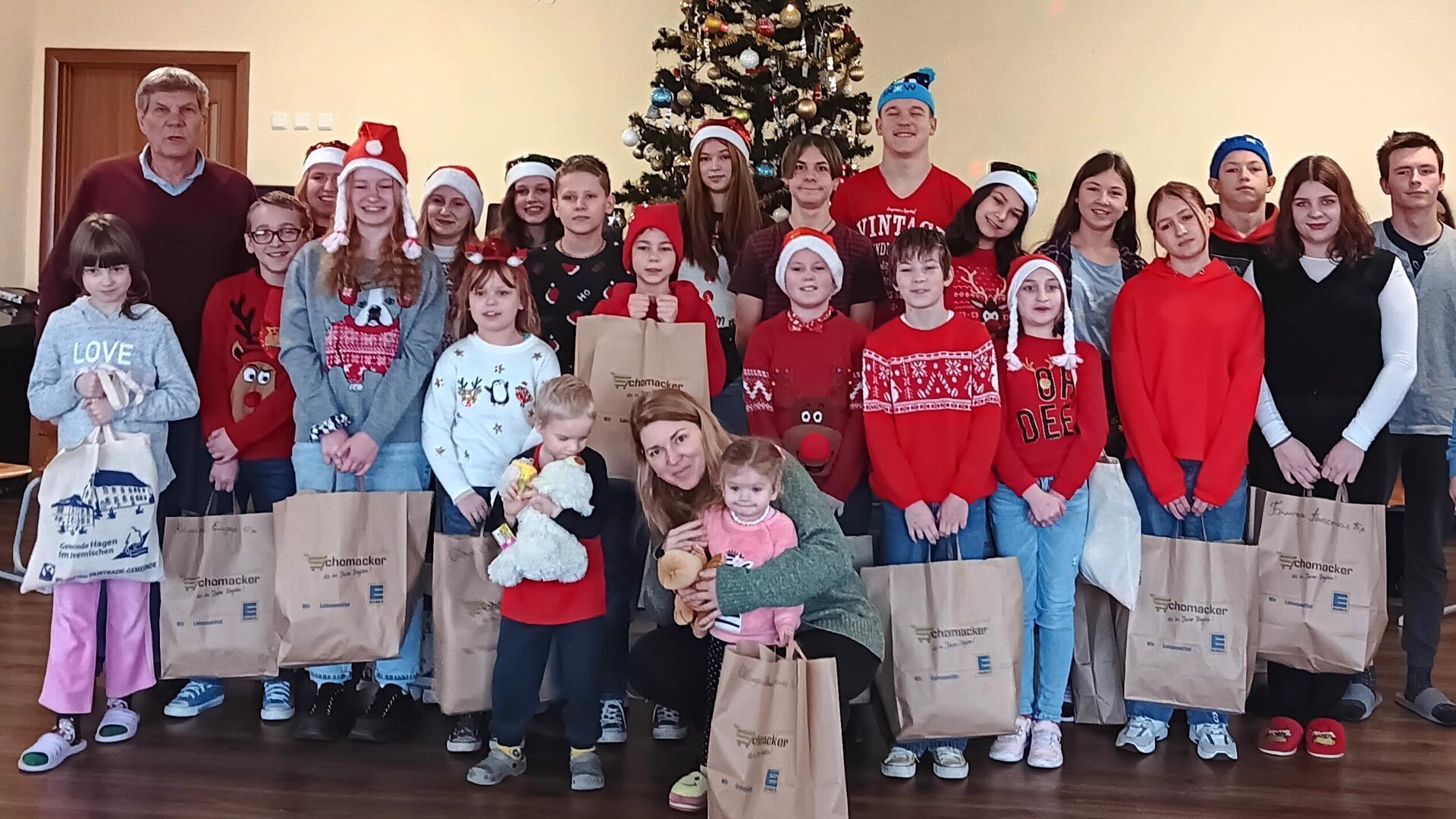 Günter Thielking (links) und Vira Seredink (vorn) übergeben Weihnachtsgeschenke an Waisenkinder in der Ukraine. 