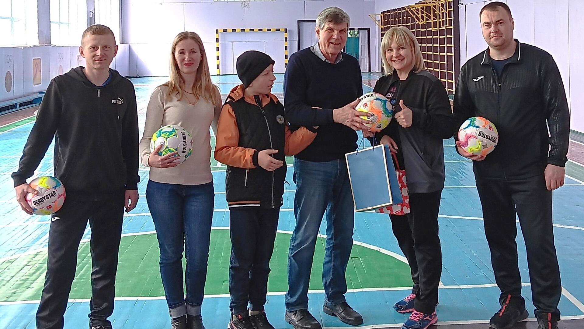 Günther Thielking (Vierter von links) überreichte bei seinem Besuch in der Ukraine als Gastgeschenk Fußbälle für den Sportunterricht an der Schule Nr. 1 in der Stadt Luzk.