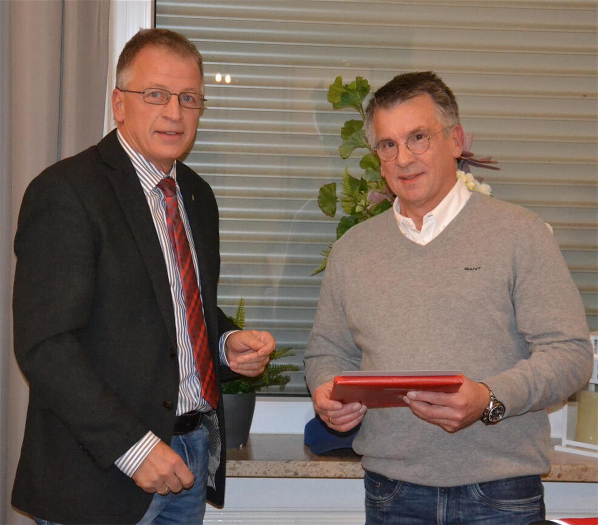 Gyhums Bürgermeister Lars Rosebrock überreicht Ralf Grabau (rechts) zum Abschied aus dem Gemeinderat eine Urkunde.