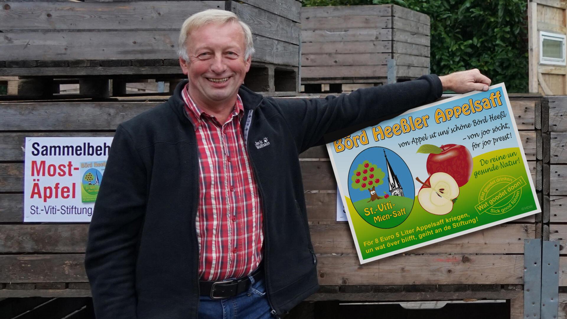 Hannes Bredehöft hält ein Plakat mit der Aufschrift "Börd Heeßler Appelsaff" in der Hand.