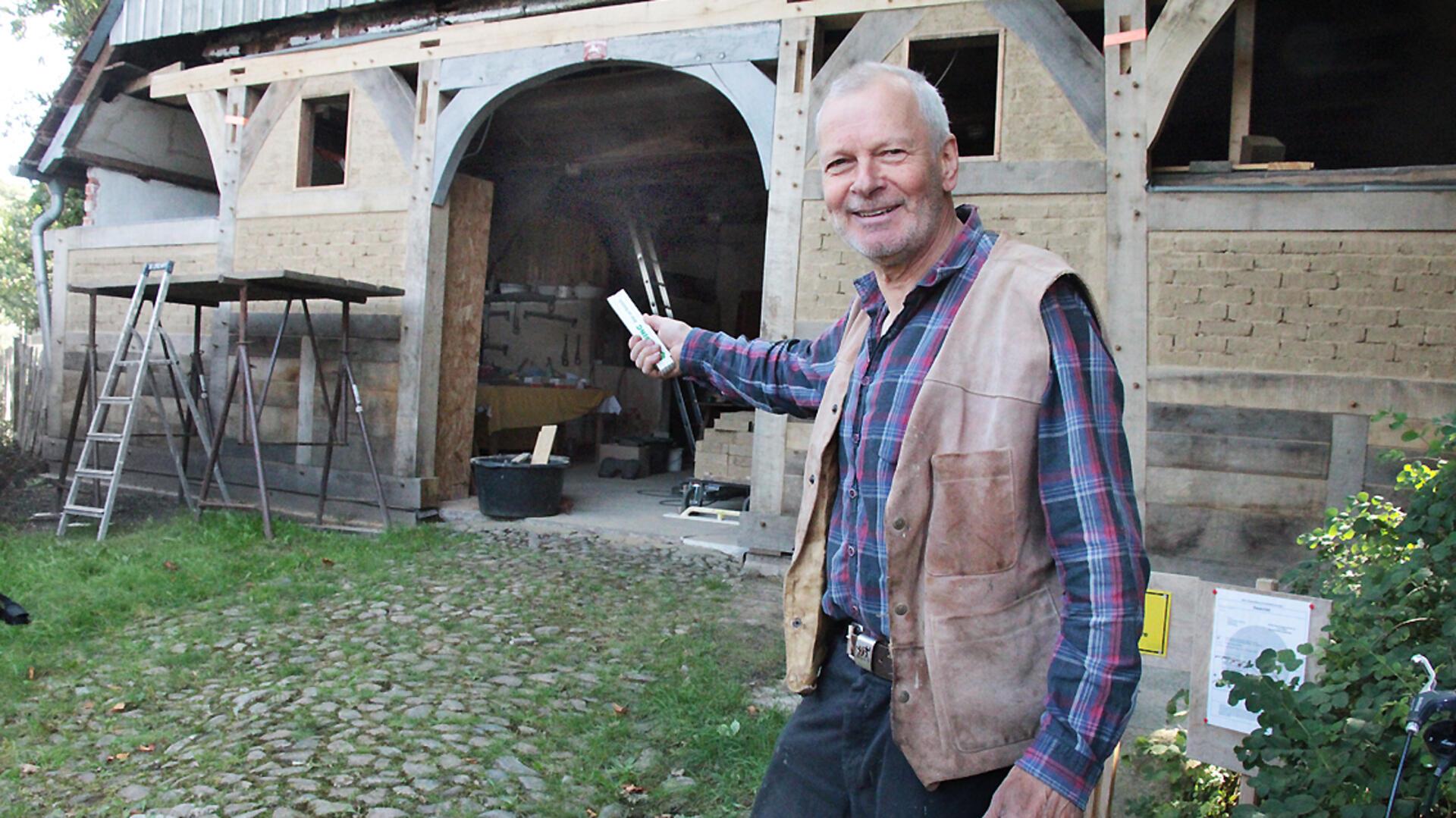 Hans-Hermann Bohling vor dem Vordergiebel des ältesten Rhader Bauernhauses, das von ihm renoviert wird.