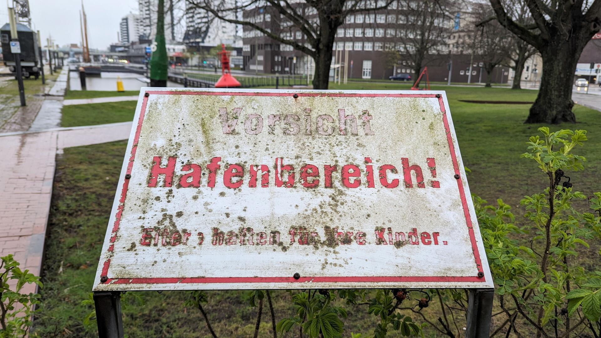 Ein Schild, auf dem steht: "Vorsicht Hafenbereich. Eltern haften für ihre Kinder" ist kaum noch zu lesen.