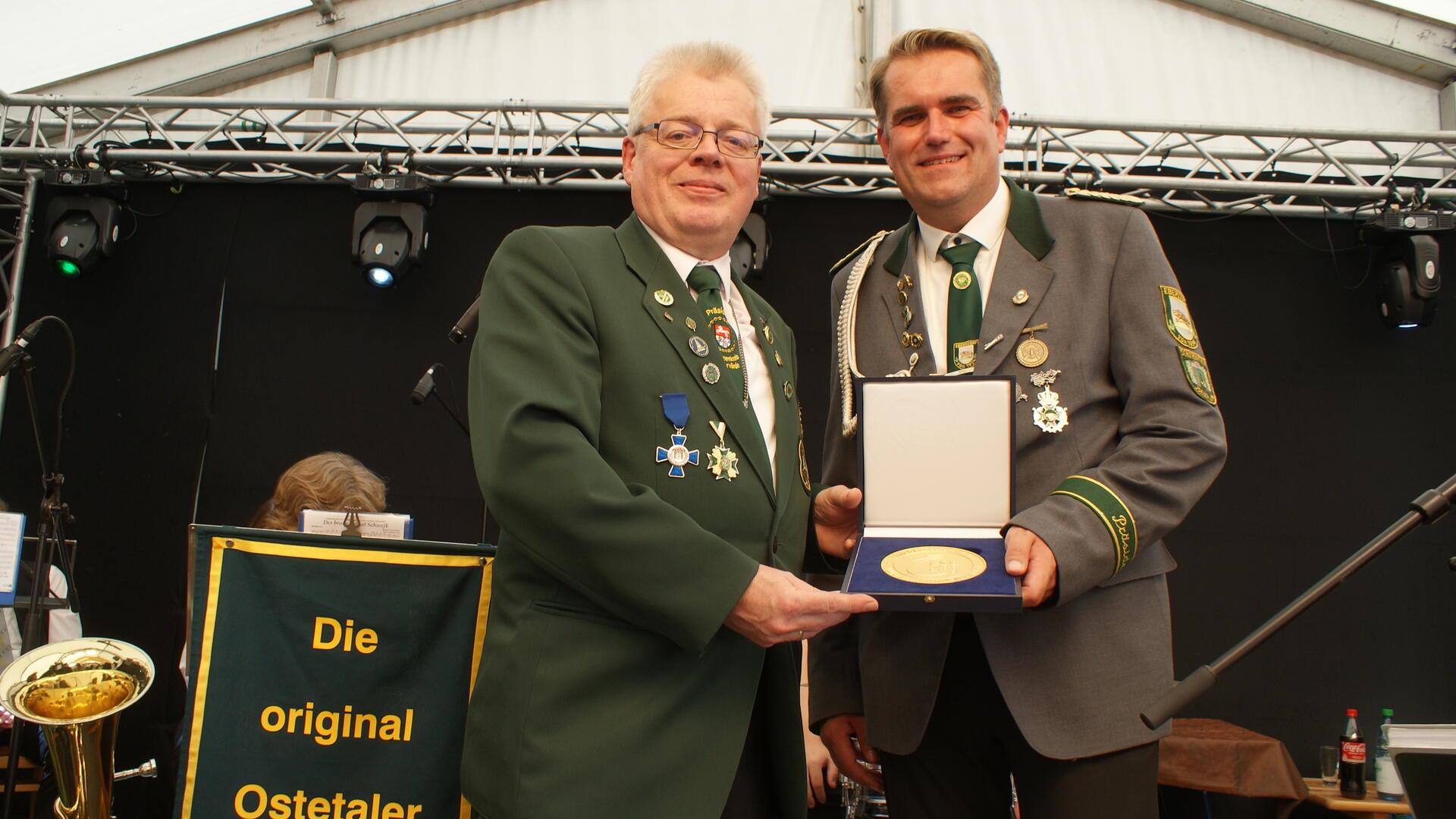 Holger Rubach (links) überreicht die Heinrich-Hünecke-Plakette an den Vorsitzenden des Schützenvereins Ebersdorf, Tim Schröder.