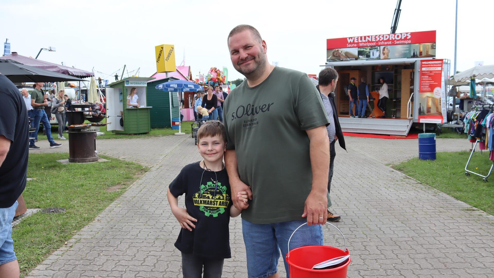 Vater und Sohn lächeln in die Kamera. 