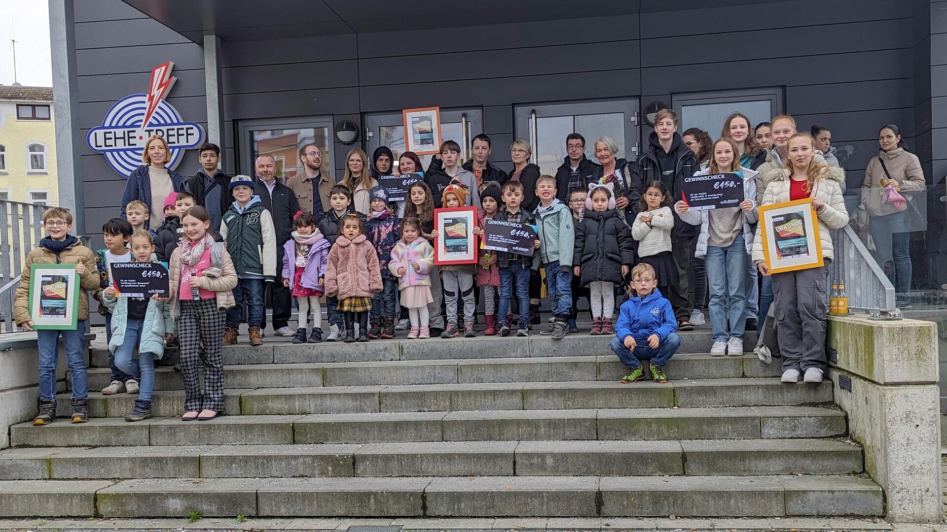  Gewinnerinnen und Gewinner des Kinder- und Jugendrechtepreises der Stadt Bremerhaven stehen auf der Treppe vor dem Lehe-Treff.