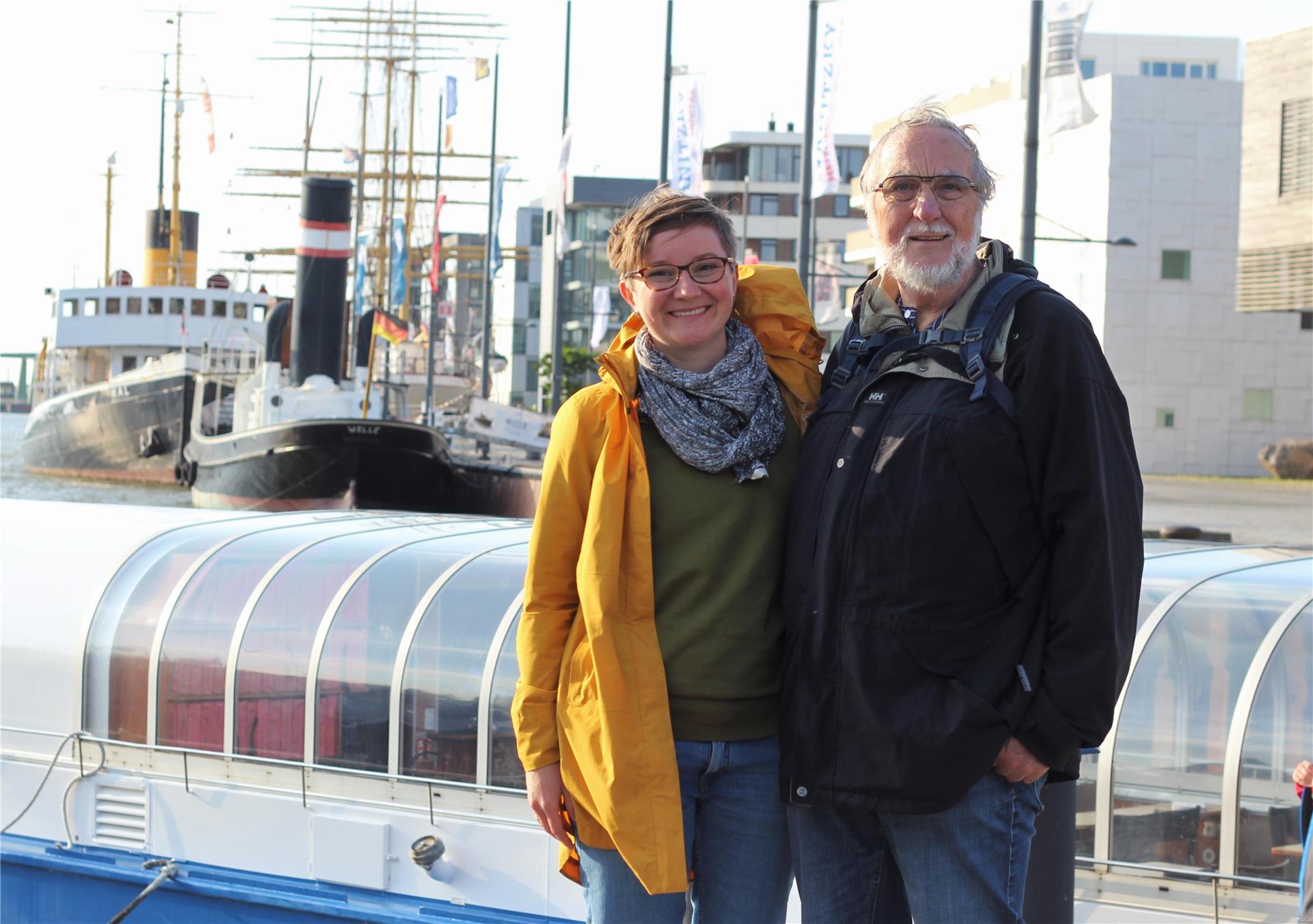 Eine Frau und ein Mann stehen am Hafen.