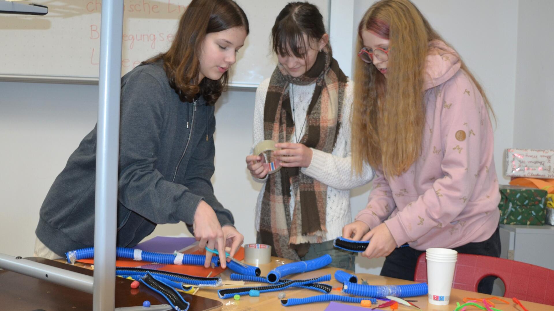 Im Workshop „Energiedomino“ tüfteln Lina Häring (von links), Hanna Behrmann und Ida Wittkowsky an der Frage, wie Energie bestmöglich genutzt werden kann. Zur Veranschaulichung bauen sie eine Murmelbahn.