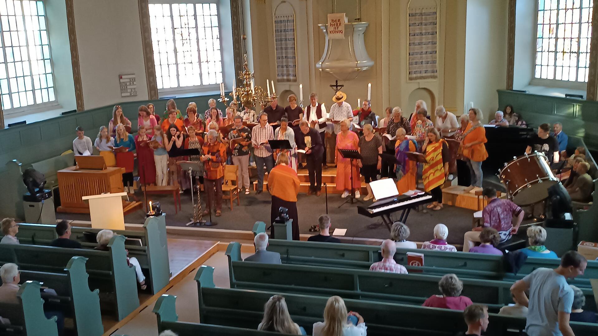 In farbenfrohen Gewändern zogen Sängerinnen und Sänger der „Joyful voices“ während des Trommel-Intros ein, um anschließend in die Bitte „Peace to the world“ einzustimmen.