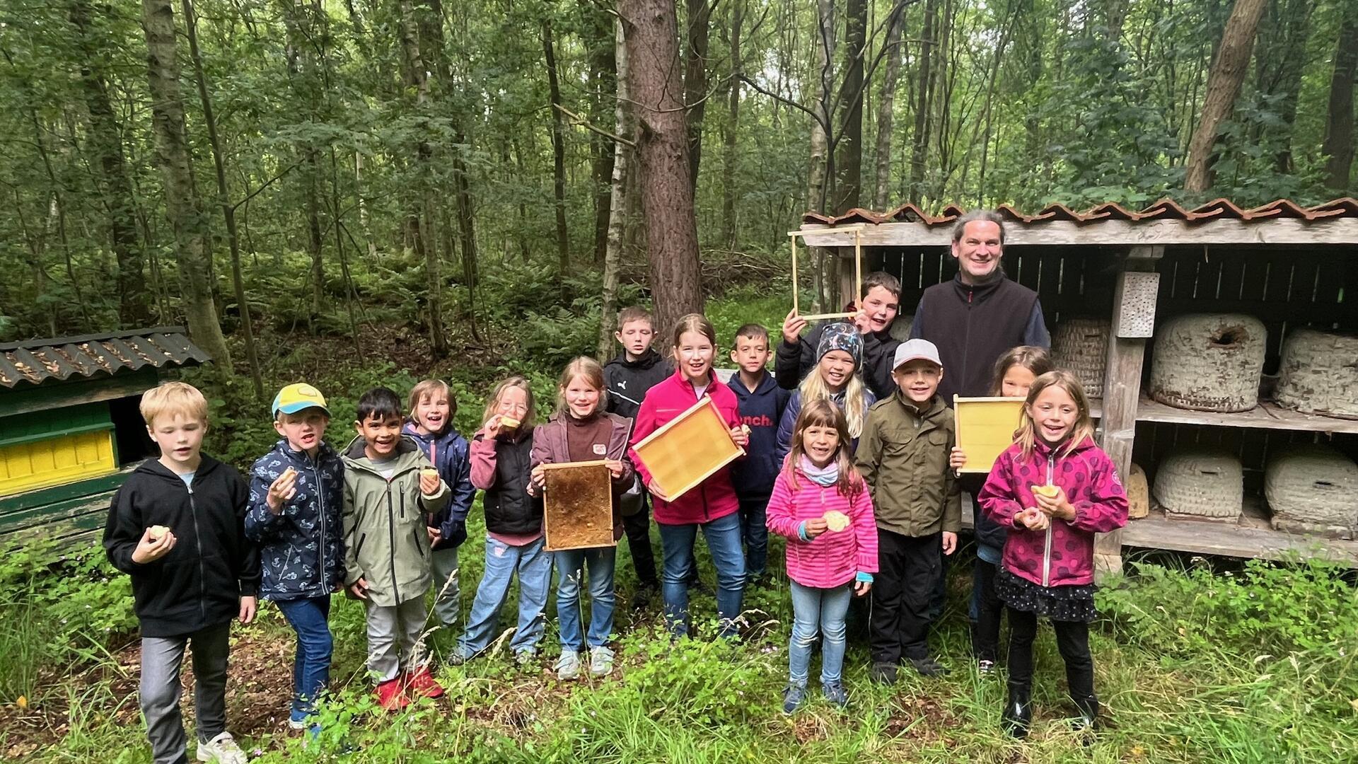 Ingo Bollmeyer vom Imkerverein Gnarrenburg mit den Kindern, die im Rahmen des Gnarrenburger Ferienspaßprogramm Einblicke in die faszinierende Welt der Honigbienen bekamen.