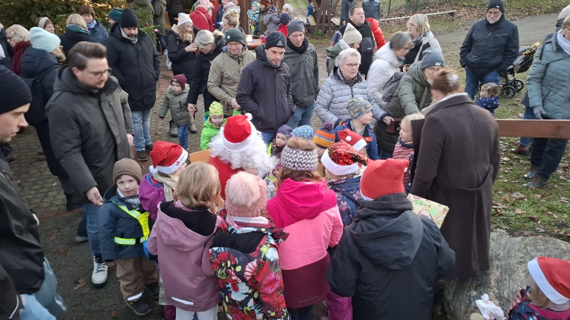 Kinder umringen einen Weihnachtsmarktstand. 