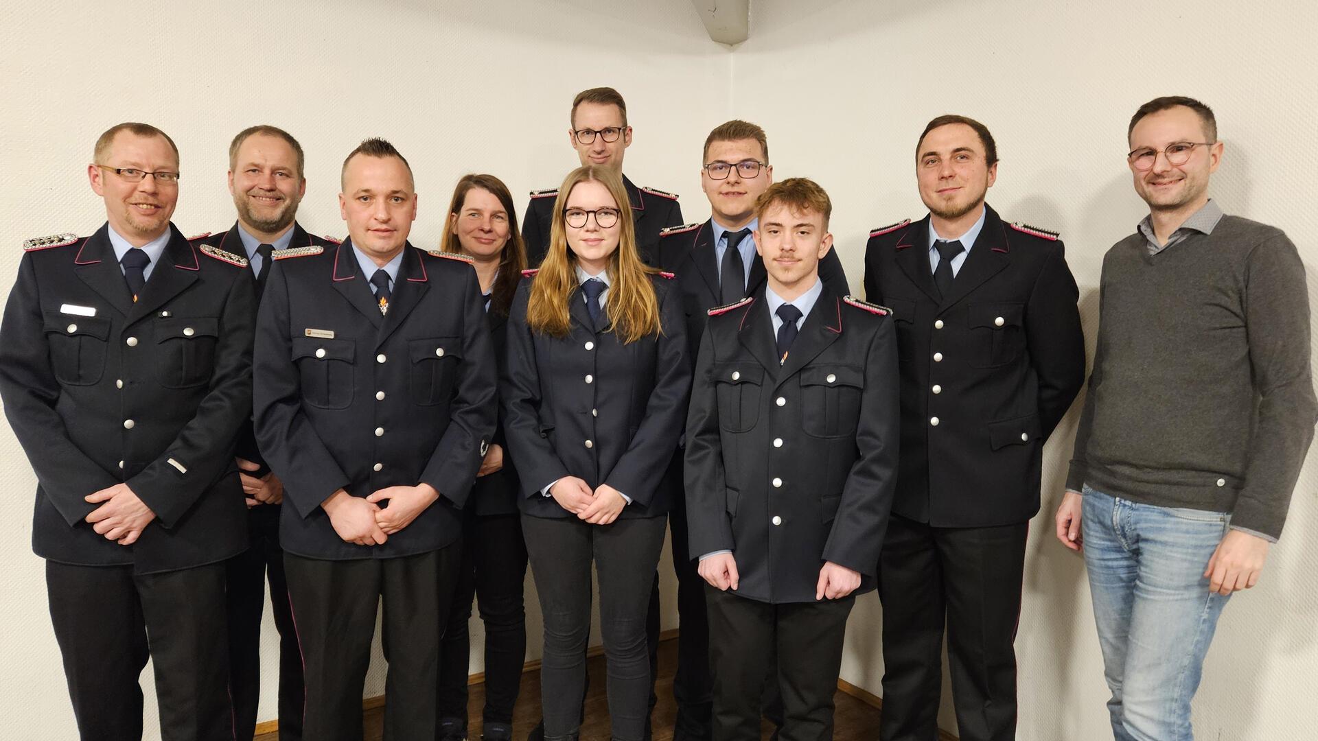 Julian Loh (rechts), stellvertretender Samtgemeindebürgermeister, mit den gewählten und beförderten Mitgliedern der Freiwilligen Feuerwehr Winkeldorf sowie Gemeindebrandmeister Björn Becker (Zweiter von links).