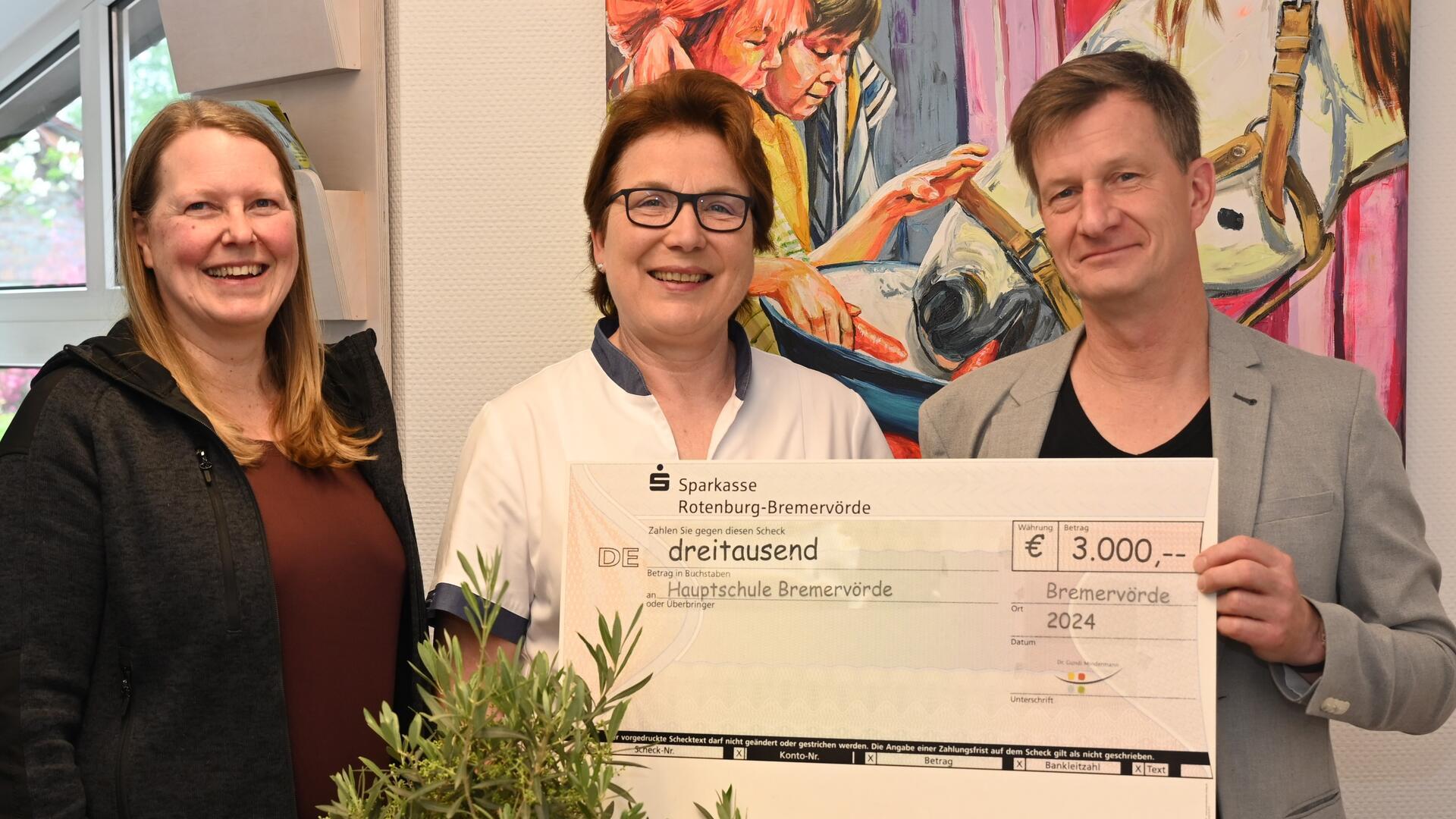 Kieferorthopädin Dr. Gundi Mindermann (Mitte) überreicht an Schulleiter Axel Müller und Ganztagskoordinatorin Gesche Kleen von der Hauptschule Bremervörde einen symbolischen Scheck über 3.000 Euro. 