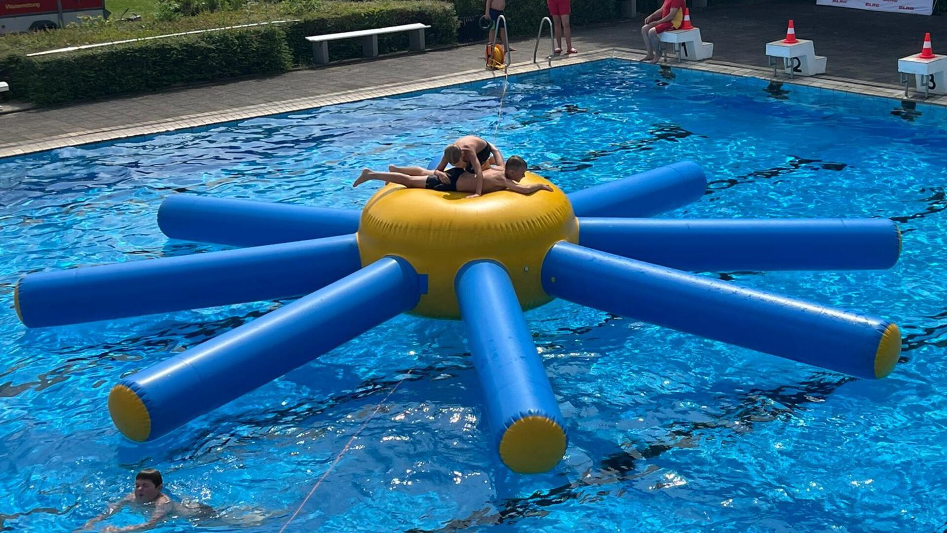 Zwei Jungs toben sich auf der Krake im Wasser aus. 