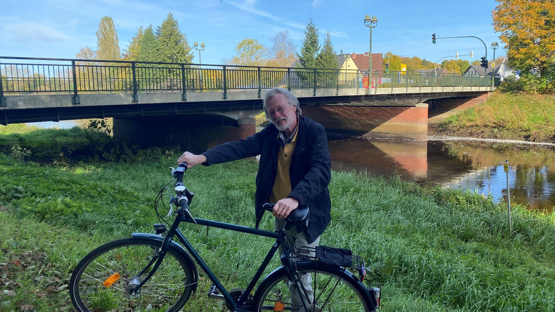 Lothar Tabery vor der Ostebrücke. Im Hintergrund sind die beiden Pfeiler zu sehen, um die es geht.