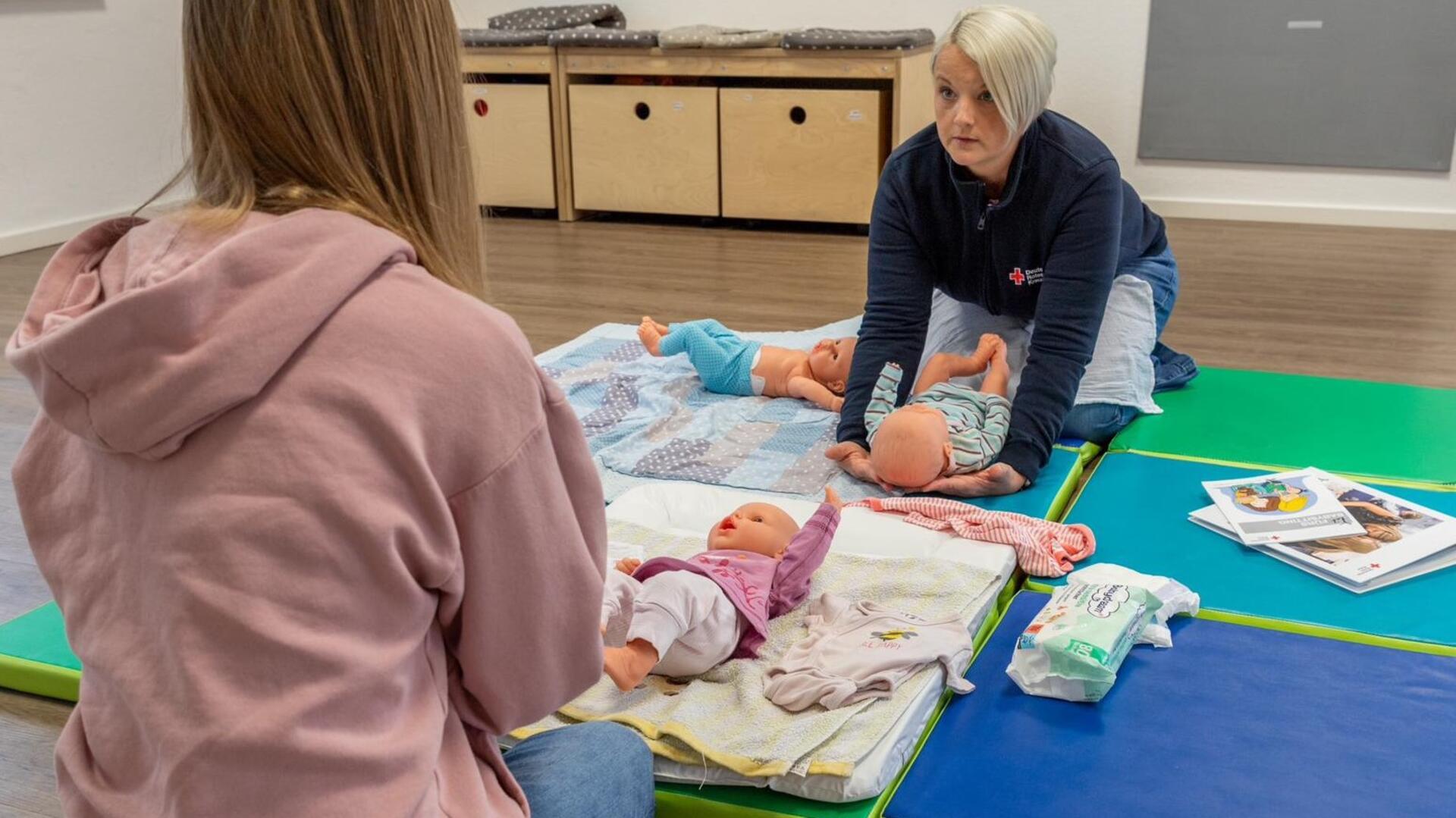 Maike Fegebank (rechts) hat drei Babypuppen gekauft, um angehenden Babysittern zu demonstrieren, wie Säuglinge richtig gewickelt werden.