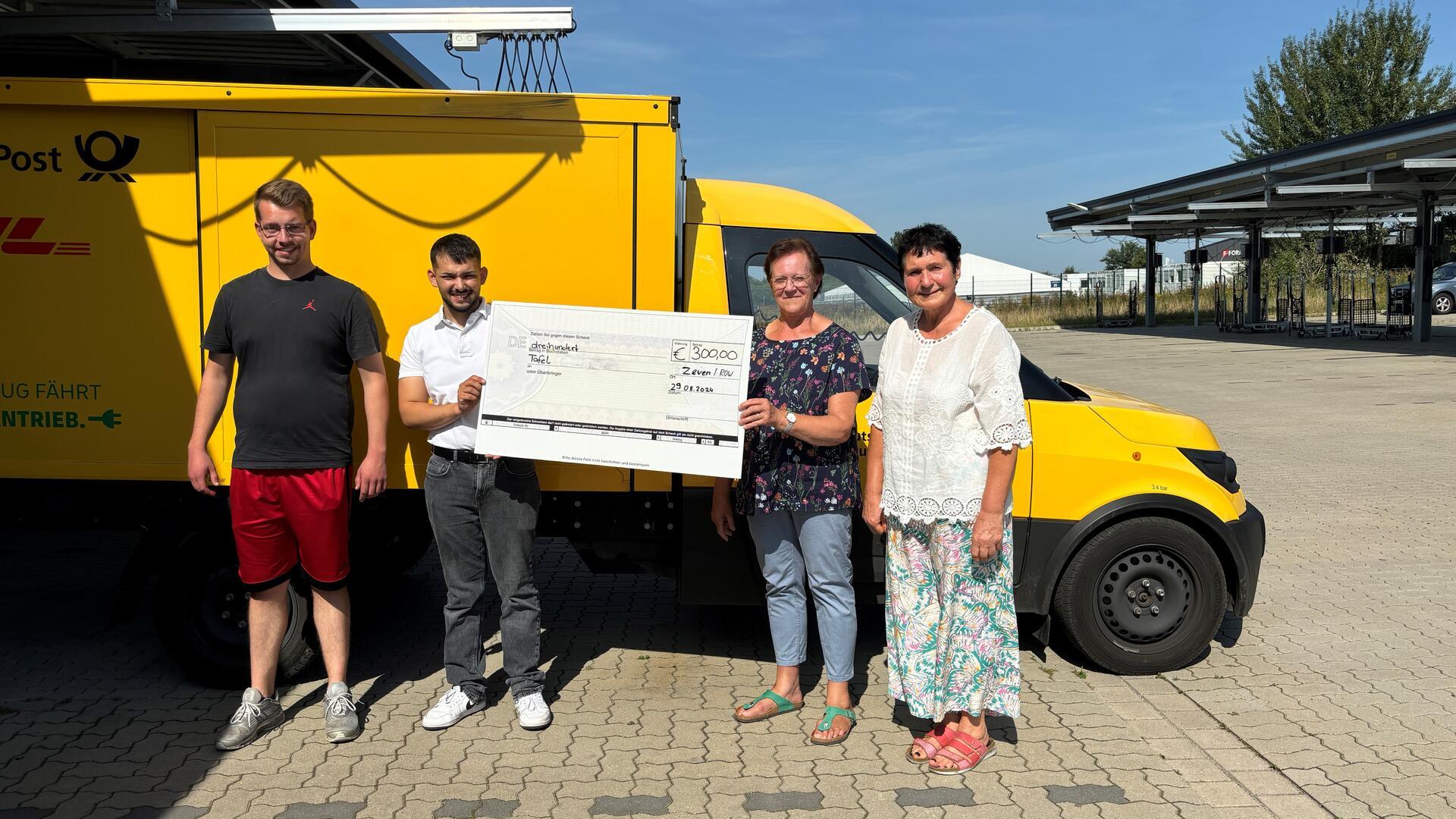 Marvin Ullrich und Abidin Say von der Jugend- und Auszubildendenvertretung der Post-Niederlassung Bremen übergeben den Leiterinnen der Tafeln in Zeven und Rotenburg einen Scheck.