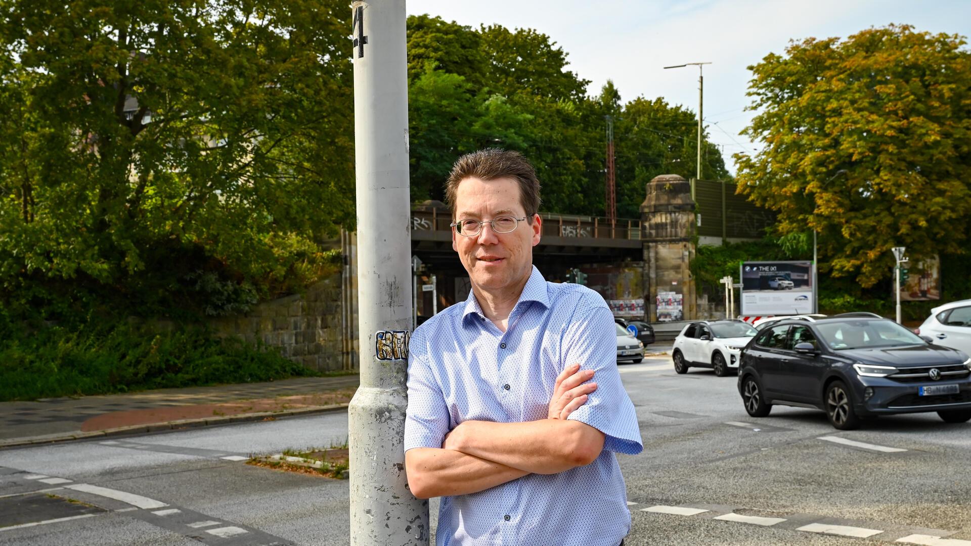 Mann lehnt an Straßenlaterne 