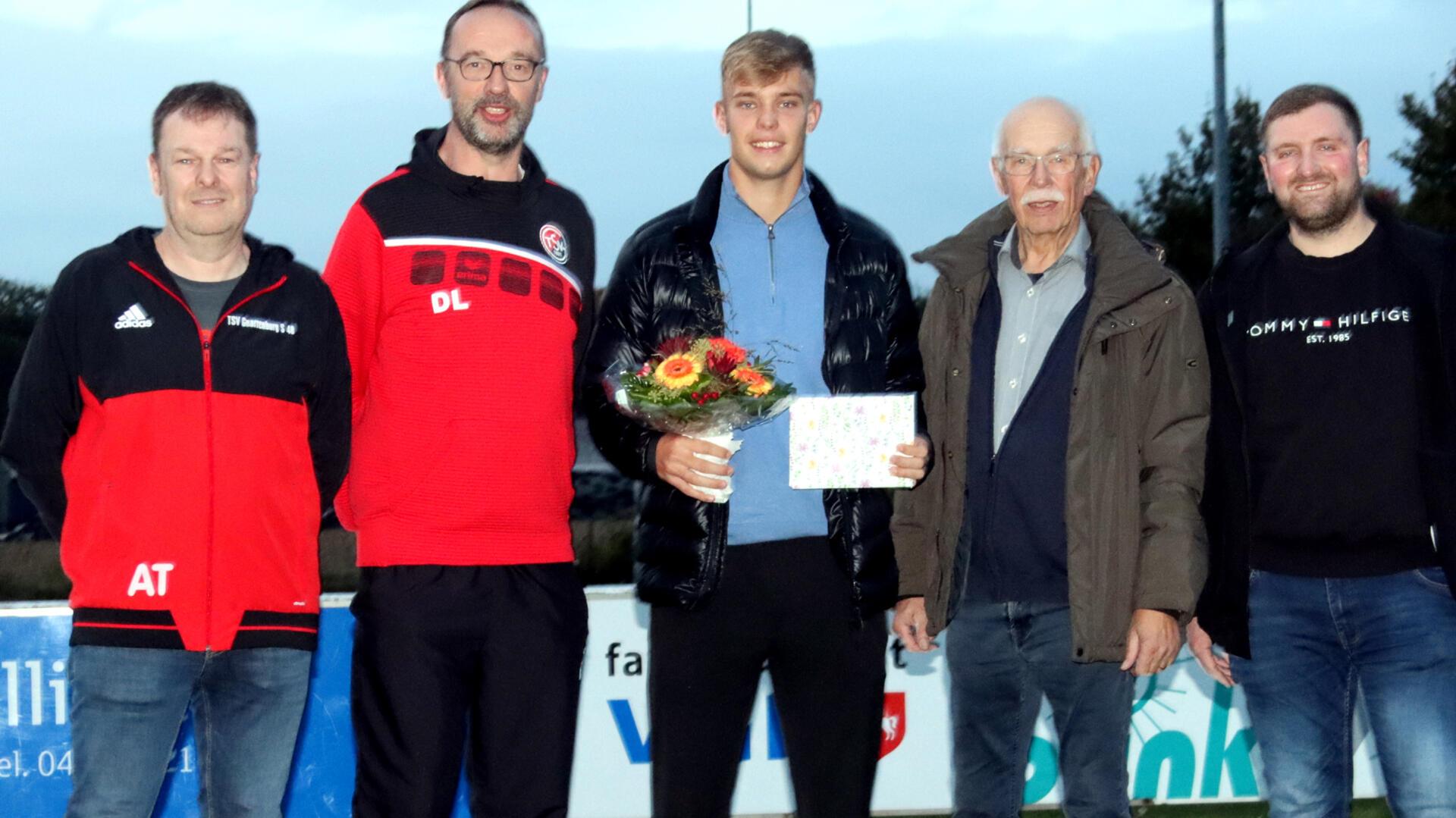 Mit Fotobuch und Blumenstrauß haben sich TSV-Vorsitzender Helmut Riggers (2. v.re.), Andreas Tietjen (li.), Dieter Lemmermann und Fabian Tietjen (re.) bei Keke Topp für den erhaltenen DFL-Geldbetrag bedankt.