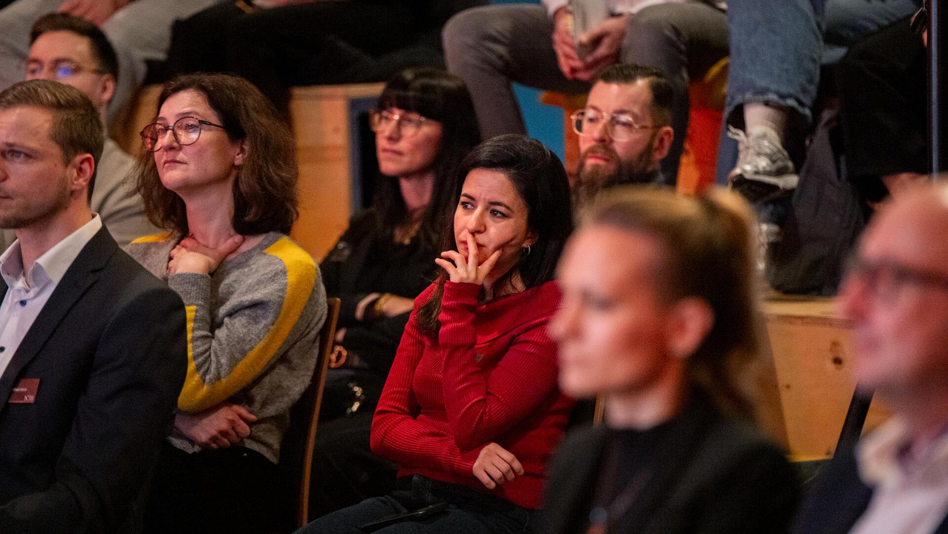 Menschen sitzen im Plenum und hören zu