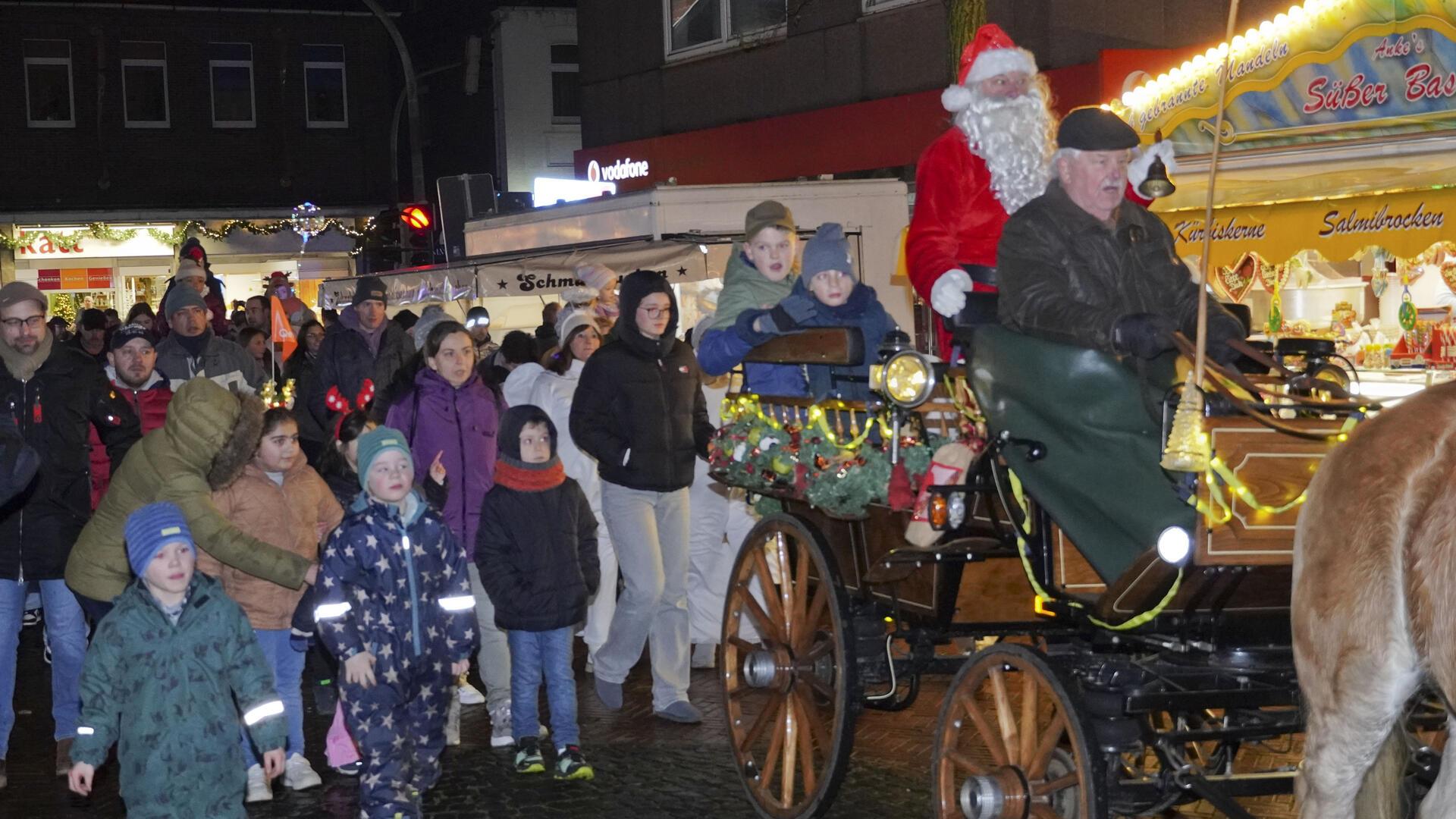 Mit der Kutsche rollte der Weihnachtsmann am Samstagabend in Begleitung von vielen Familien und einer Schar Weihnachtsengel auf den Bremervörder Weihnachtsmarkt.