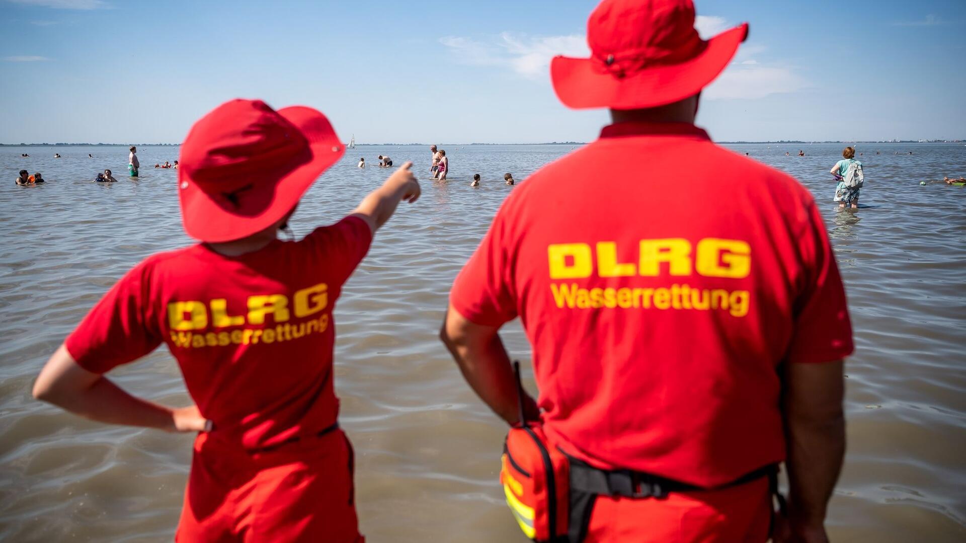 Mitglieder der DLRG (Deutsche Lebens-Rettungs-Gesellschaft) stehen am Strand von Dangast.