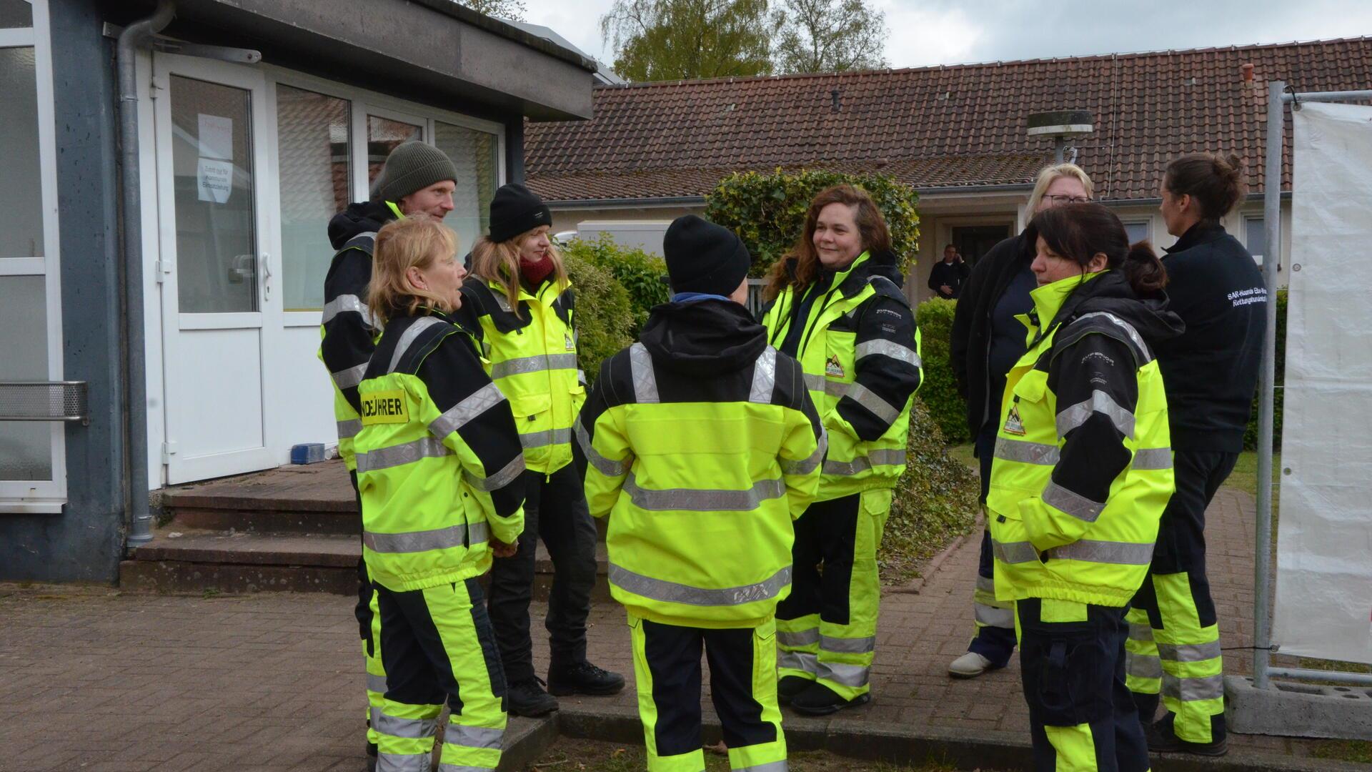 Mitglieder einer Mantrailer-Hundestaffel bereiten sich vor dem Elmer Feuerwehrhaus auf ihren Einsatz vor. 