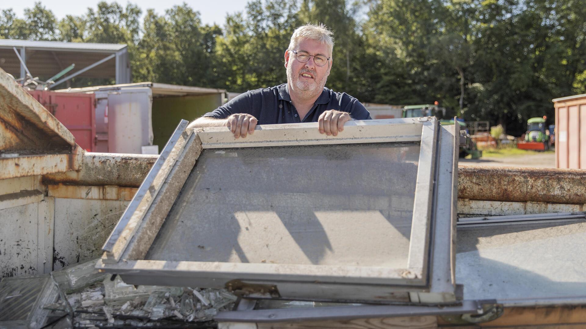 Ein Mann hält ein Fenster mit Rahmen