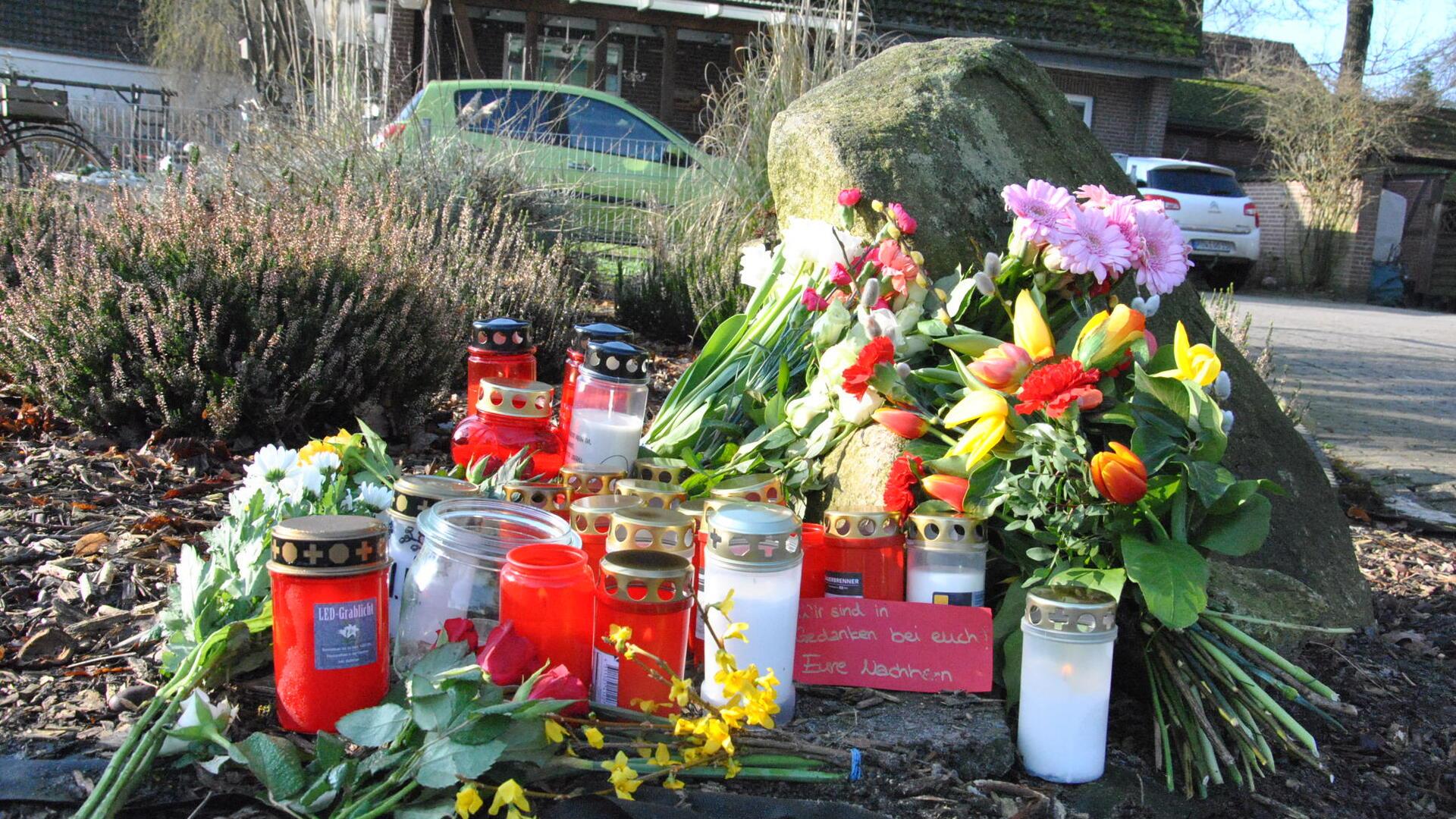 Blumen und Kerzen liegen an einem Grundstück.