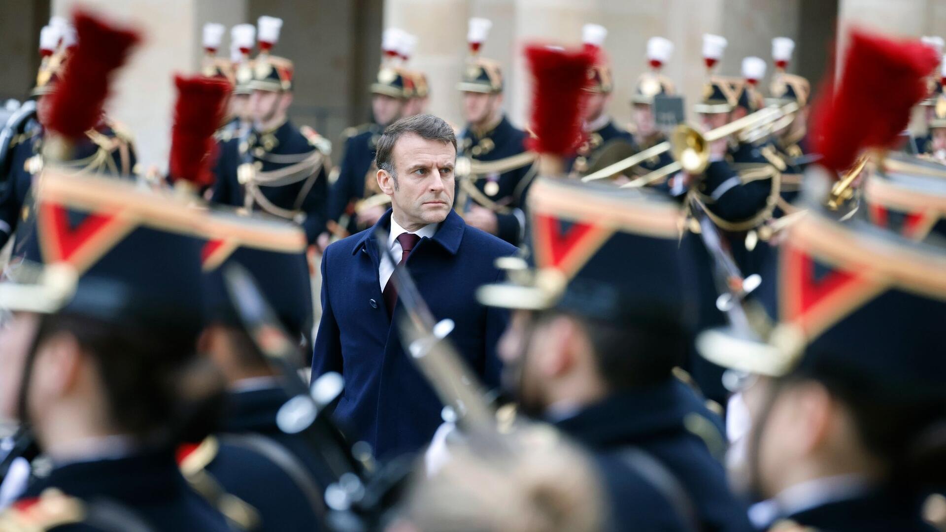 Nationalfeiertag in Frankreich: Der französische Präsident Emmanuel Macron wird während einer militärischen Zeremonie im Innenhof des Hotel National des Invalides in Paris von Truppen umringt.